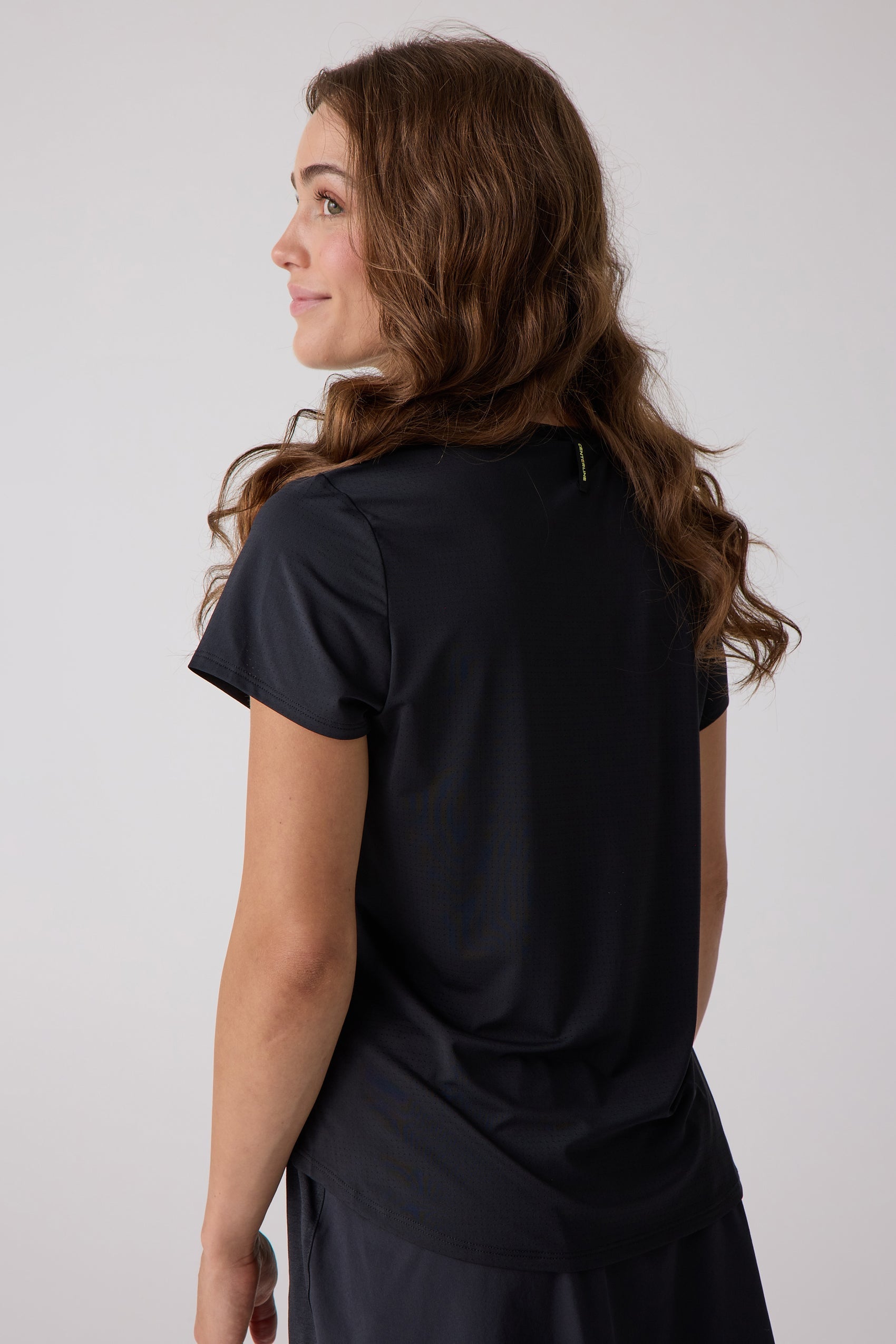 Black mesh short sleeve tee by Centerline Athletics, with a yellow neck label, worn in a side-back view.