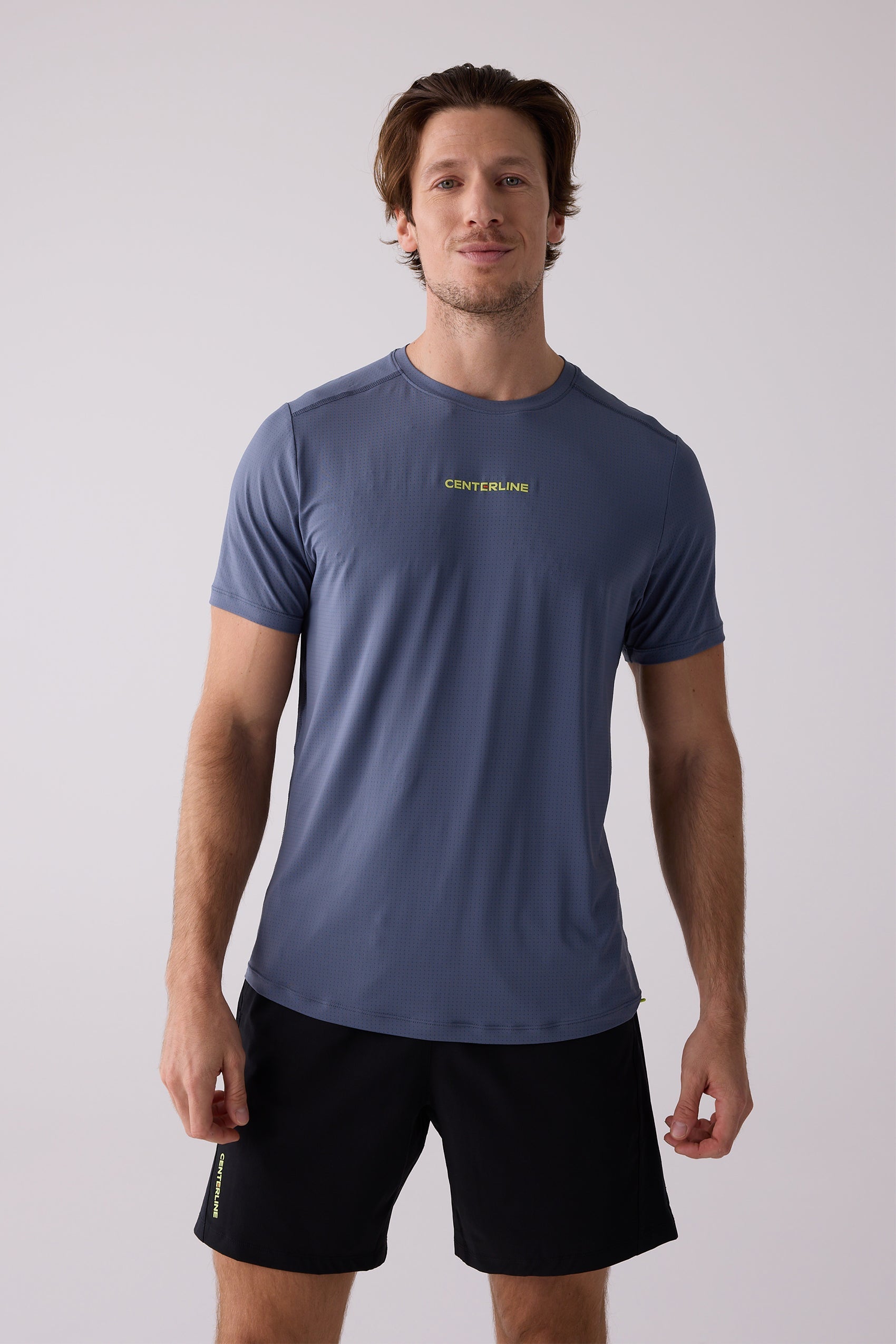 Men's blue AirLite Tee by Centerline Athletics, featuring a subtle perforated texture and neon yellow logo.