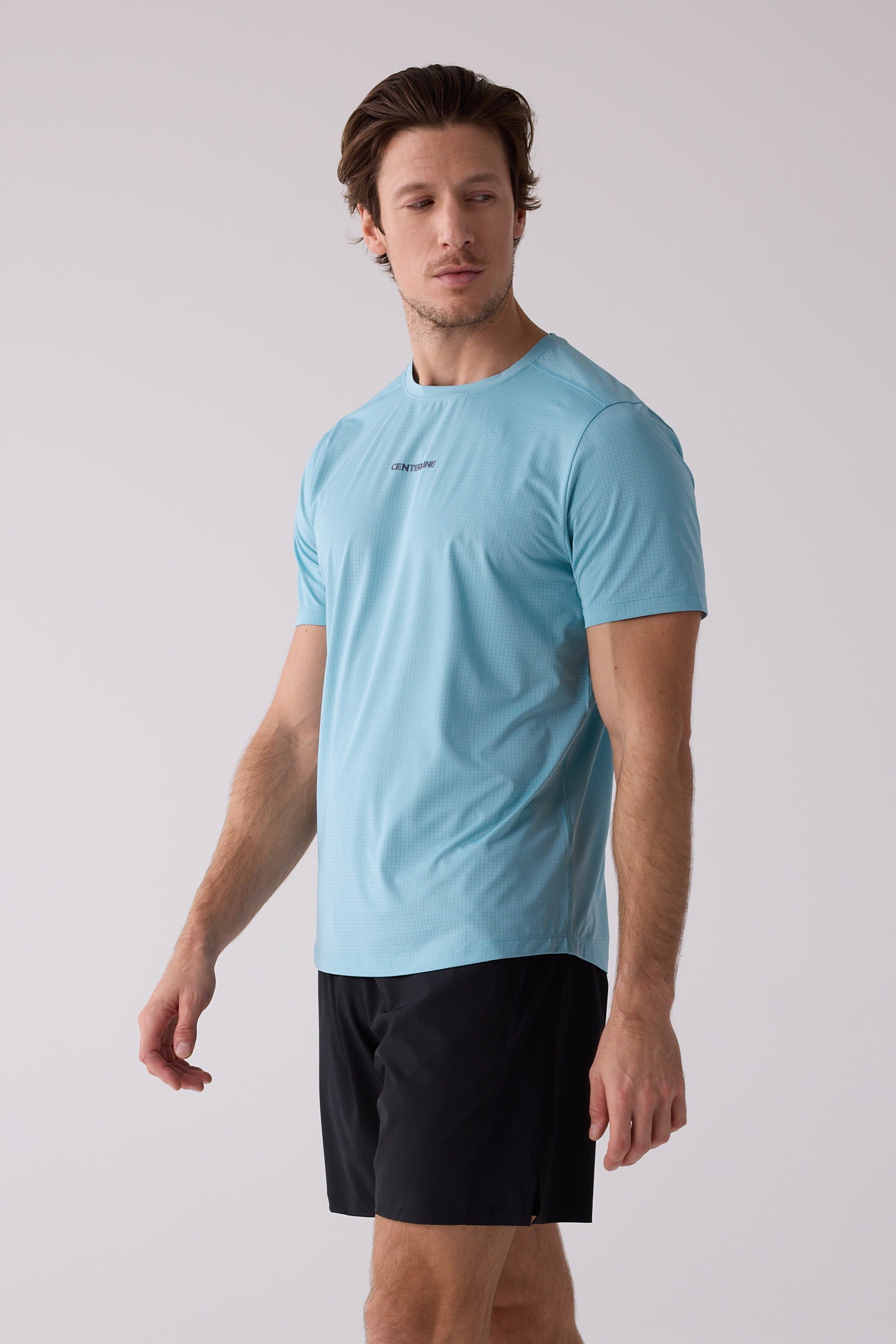 Light blue men's t-shirt by Centerline Athletics with a perforated texture and small chest logo, worn with black shorts.