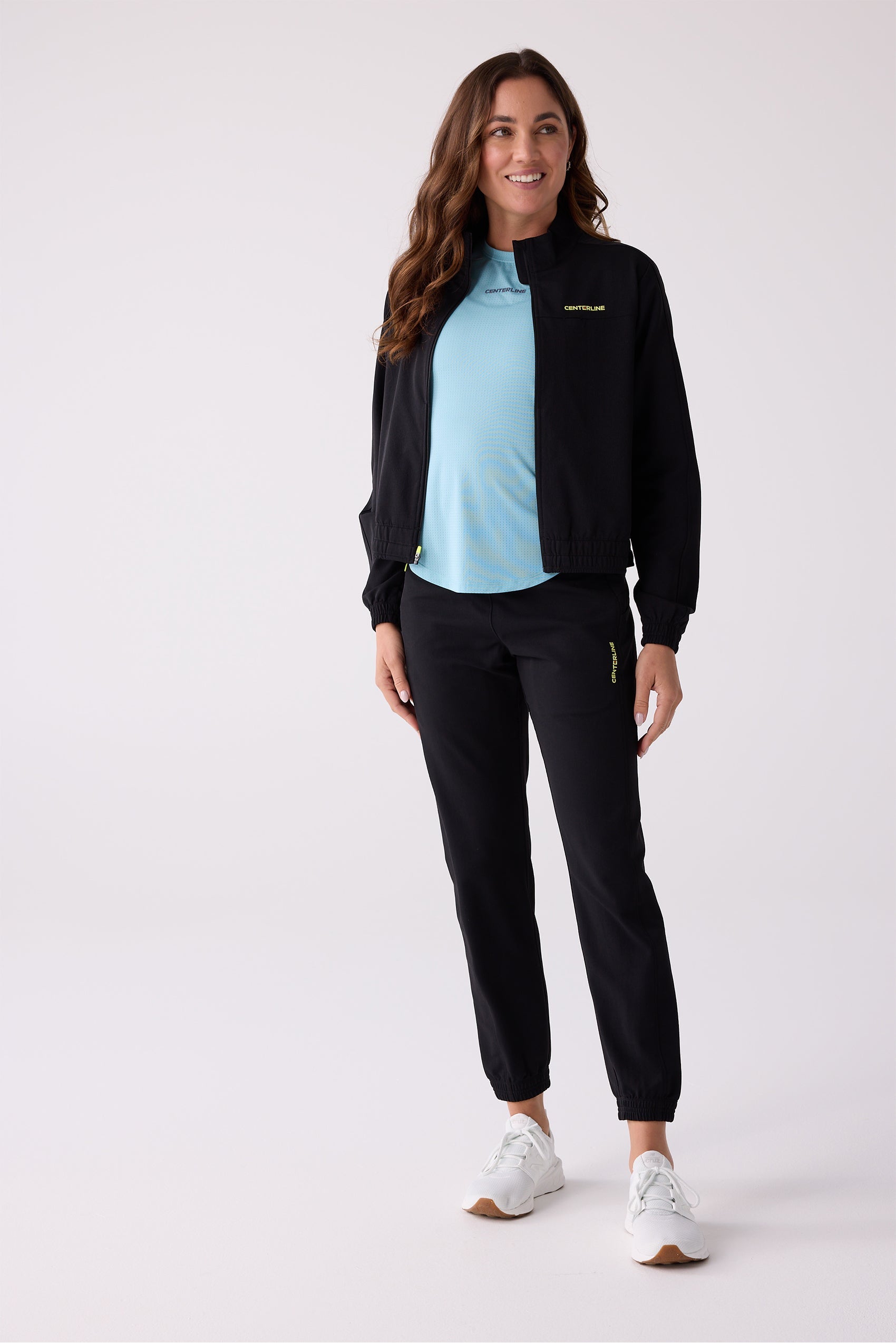 Light blue women's short sleeve tee by Centerline Athletics, with perforated texture and chest logo, worn under a black jacket.