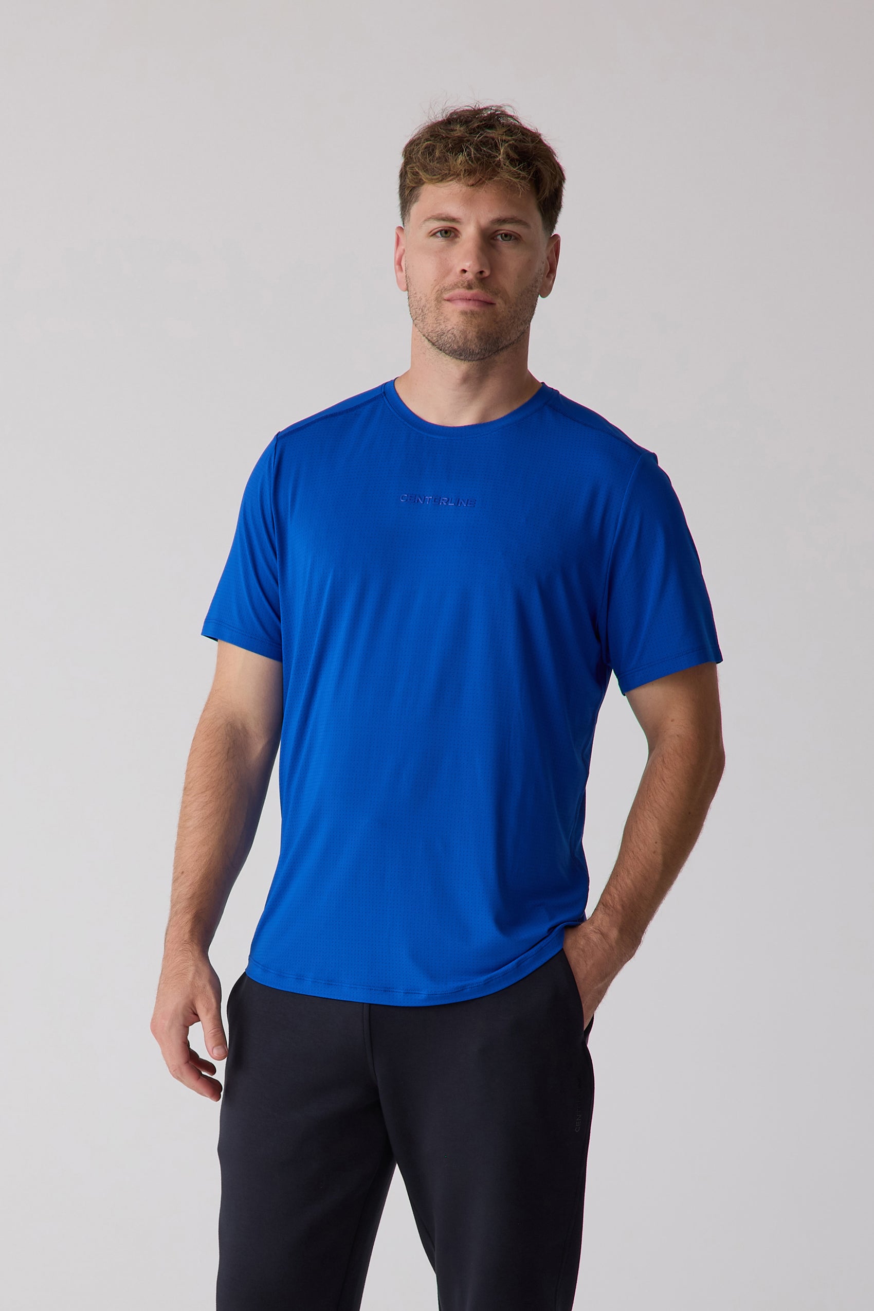Royal blue micro-dot men's tee by Centerline Athletics, featuring a subtle chest logo and worn with black pants.