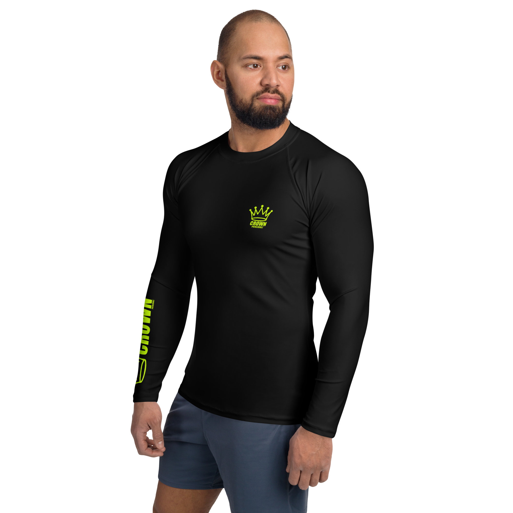 Man wearing a black long-sleeved shirt with a neon green logo and lettering, paired with gray shorts.