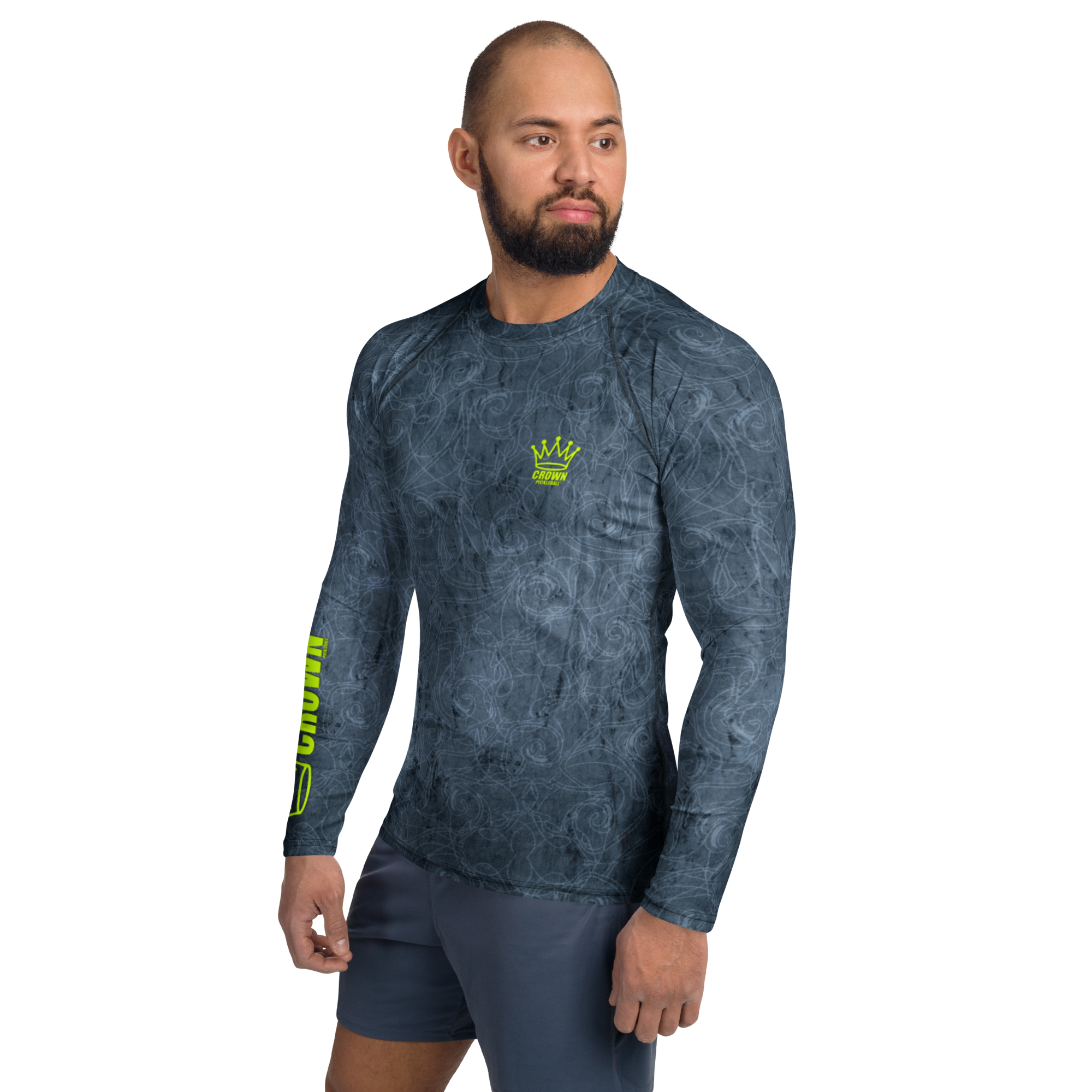 A man wearing a long-sleeved, patterned gray shirt and gray shorts.