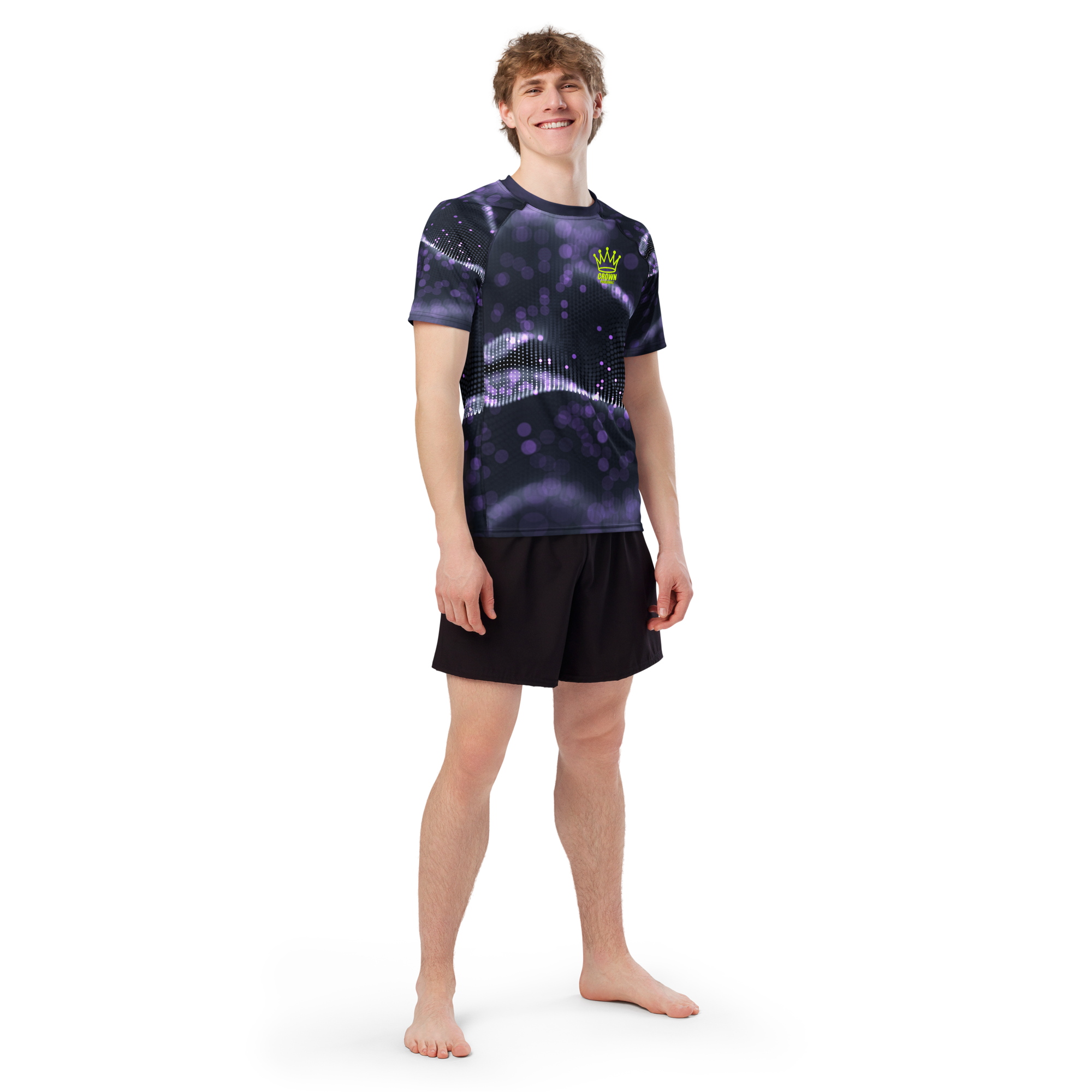 A man in a t-shirt and shorts stands barefoot in a studio.