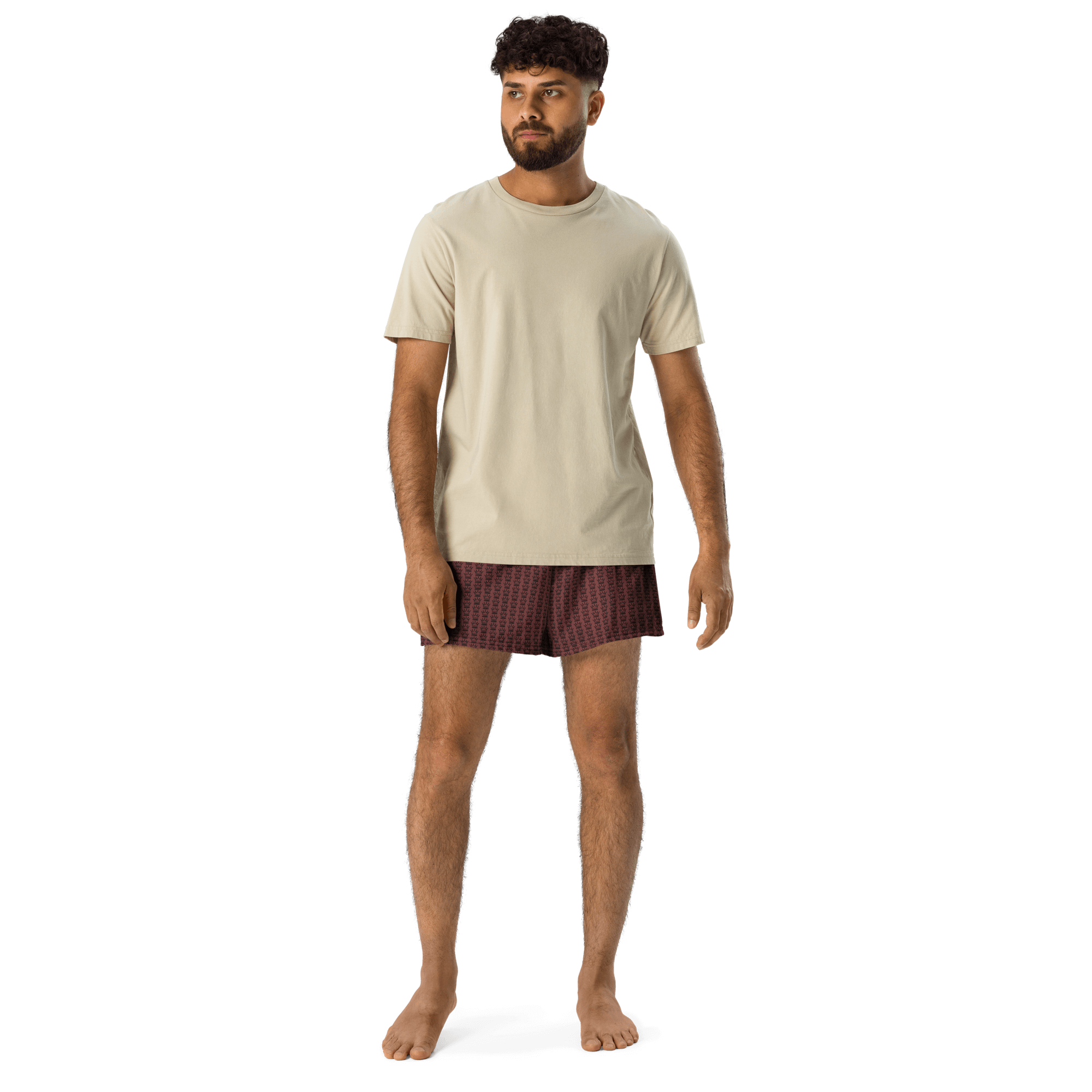 A man wearing a beige t-shirt and patterned boxers.