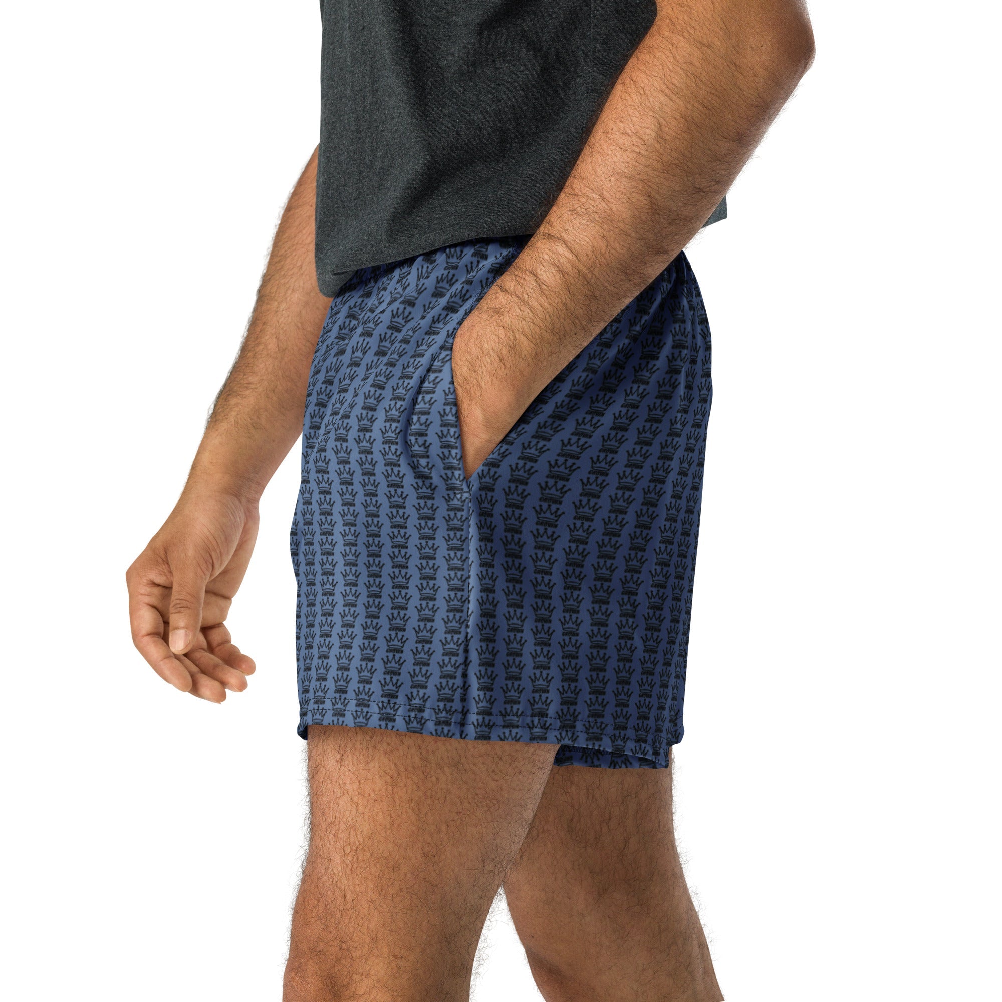 Man in gray shirt and blue shorts with black crown pattern.