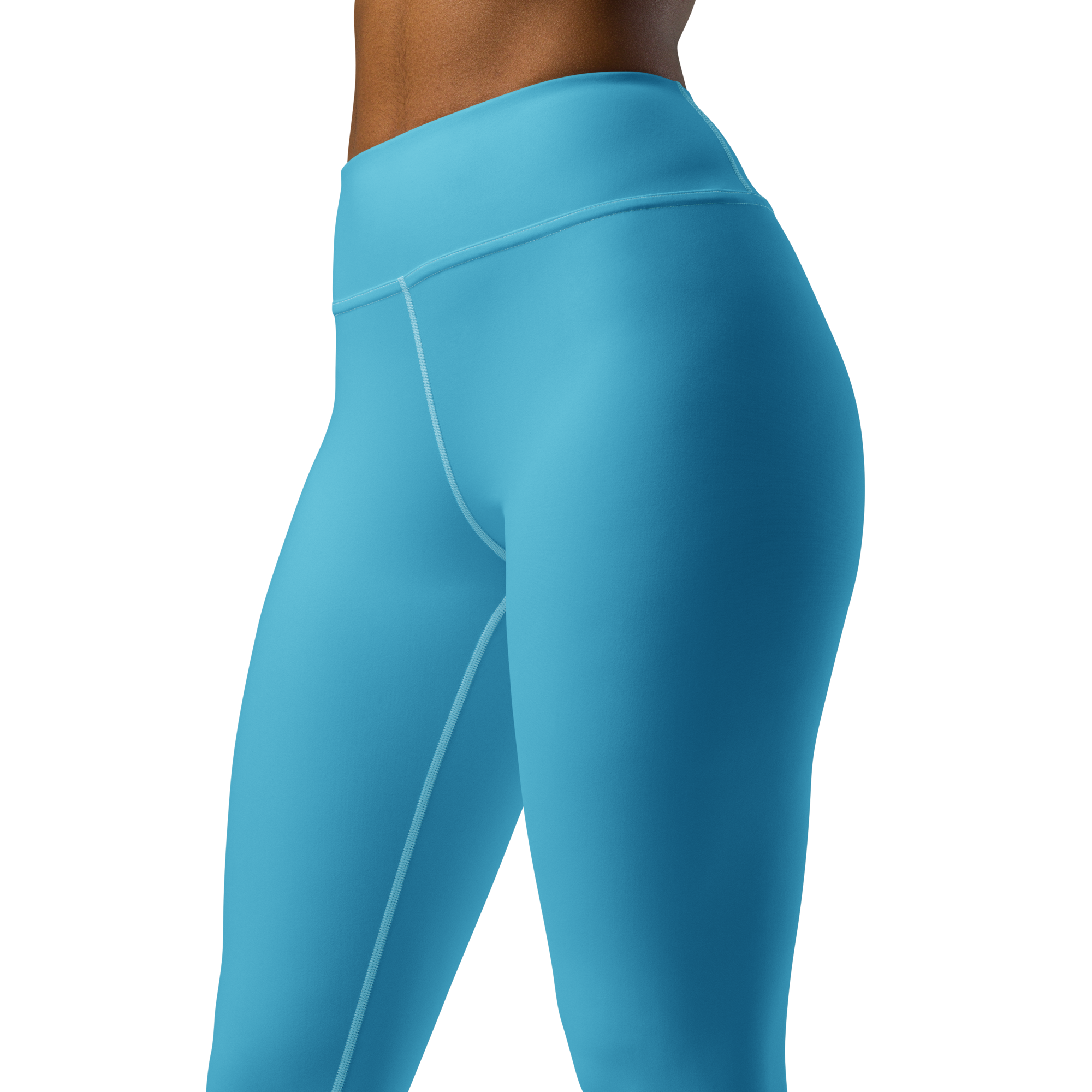 Side view of woman wearing blue leggings against black background.