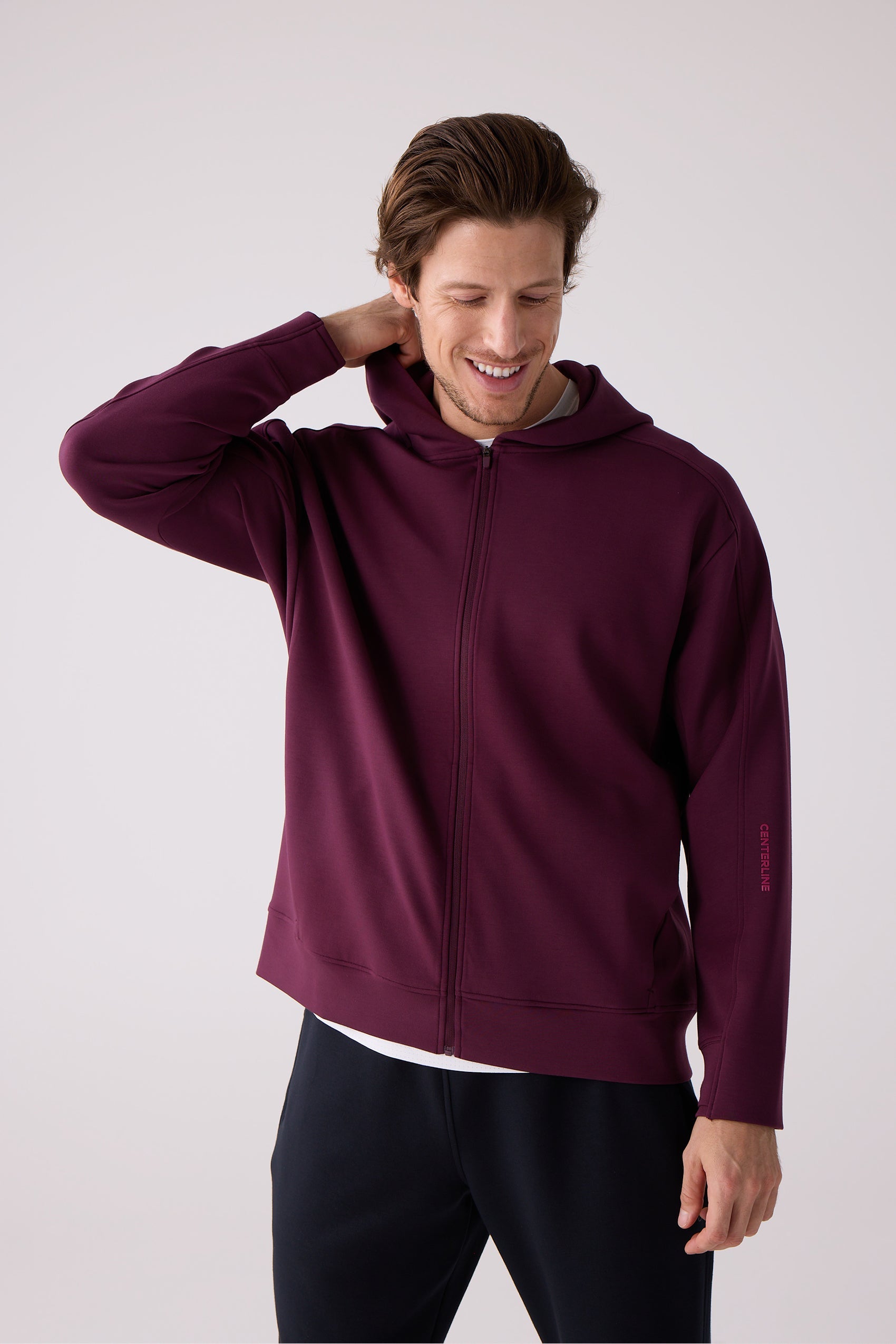Maroon full-zip hooded sweatshirt by Centerline Athletics, featuring "CENTERLINE" text on the left sleeve, worn by a man with dark trousers.