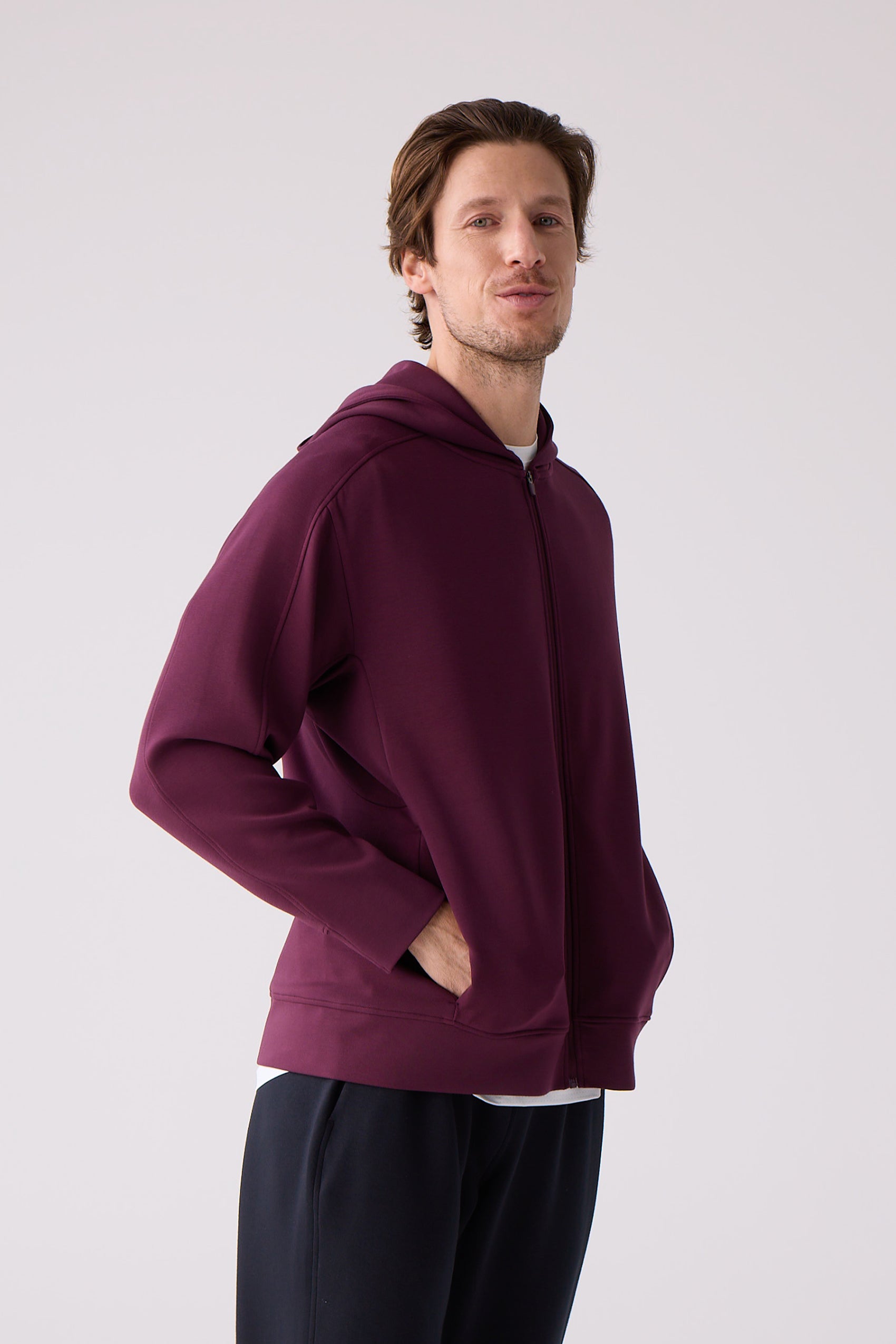 Burgundy Après Unisex Crew Sweatshirt by Centerline Athletics, featuring a full zipper and hood, worn by a man.