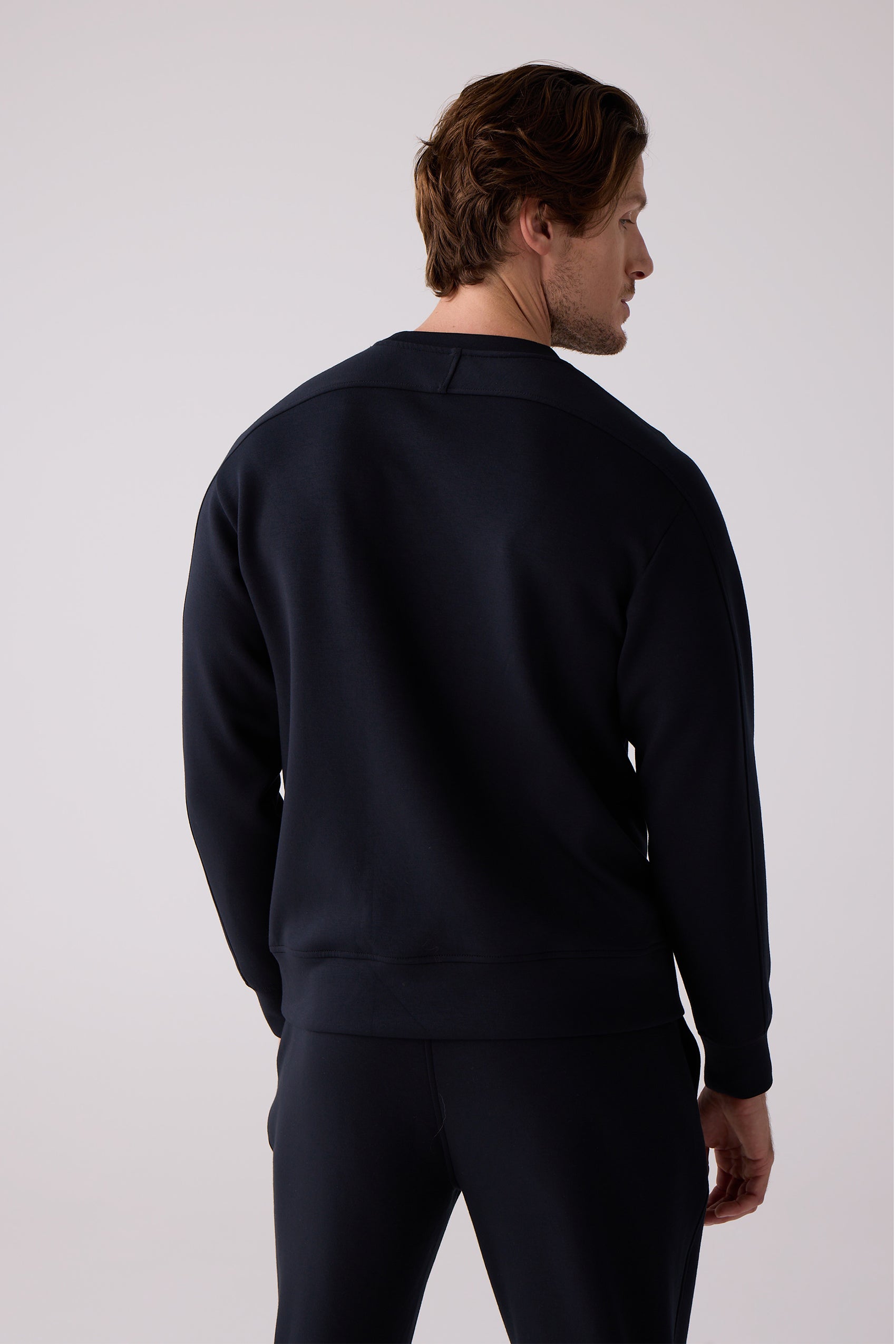 Men's dark navy crew sweatshirt by Centerline Athletics, with ribbed cuffs and hem, worn with matching sweatpants from the back.