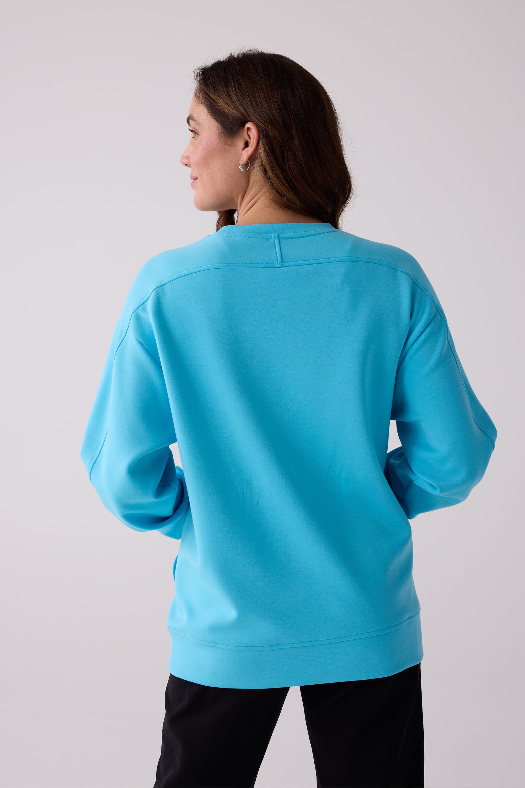 Bright blue women's crew sweatshirt by Centerline Athletics with dropped shoulders and ribbed hem, shown from the back.