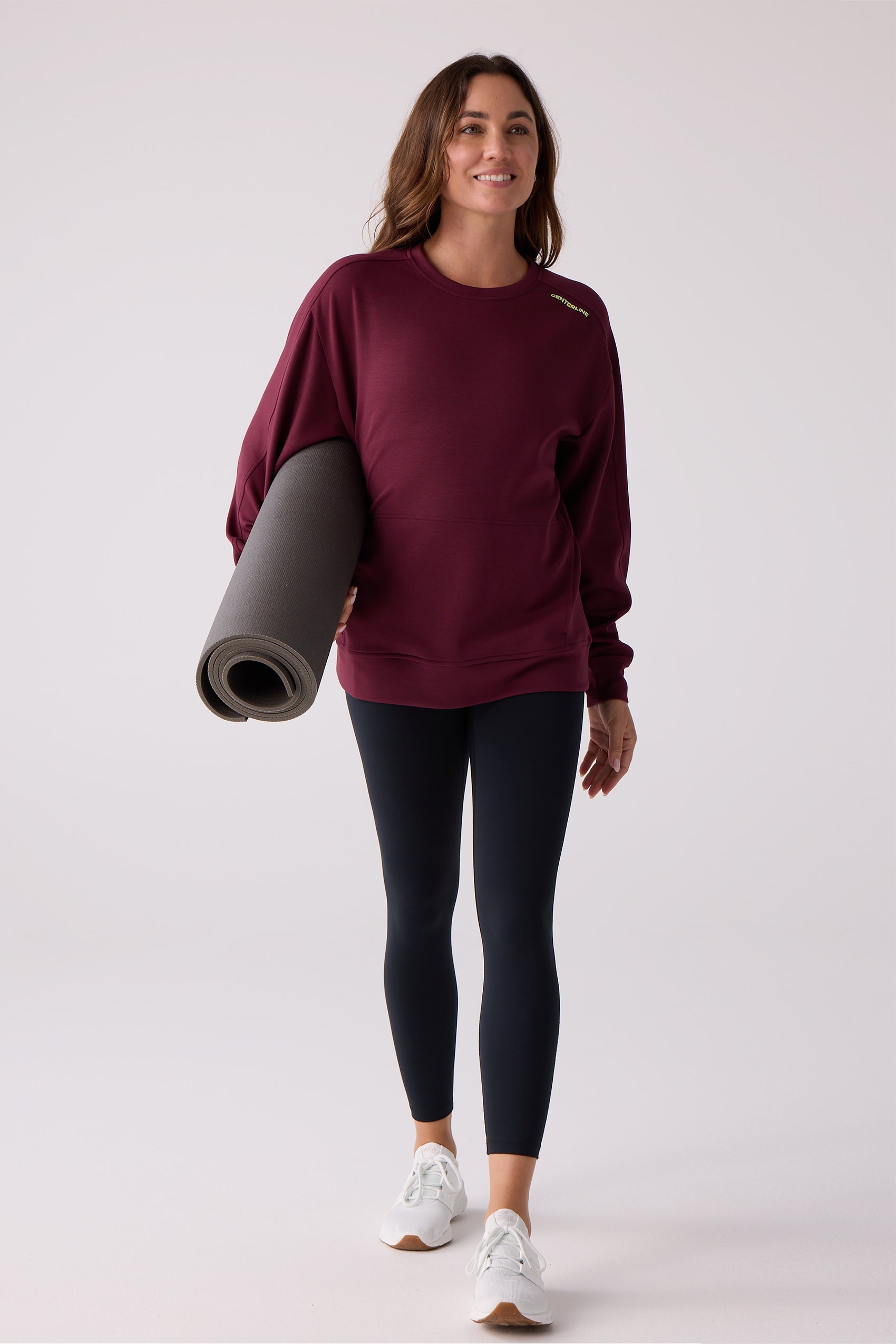 Deep burgundy crew sweatshirt by Centerline Athletics, with yellow "CENTERLINE" text on the left shoulder, worn by a woman holding a yoga mat.