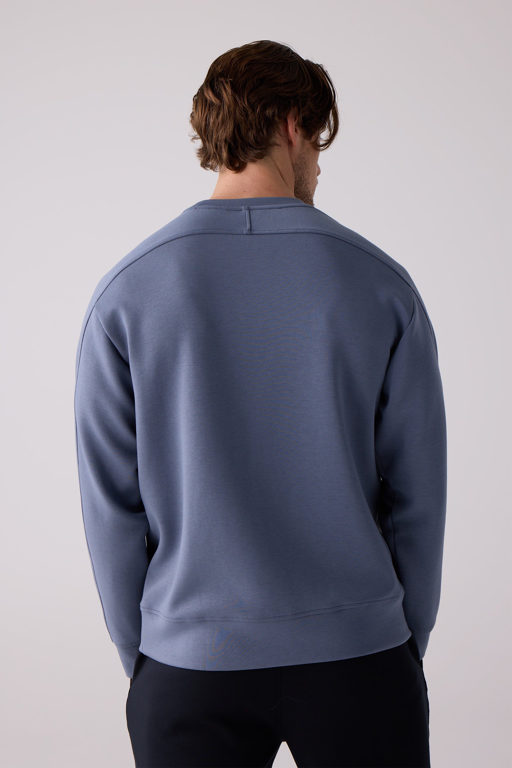 Slate blue Men's Crew Sweatshirt by Centerline Athletics, shown from the back with dropped shoulders and black pants.