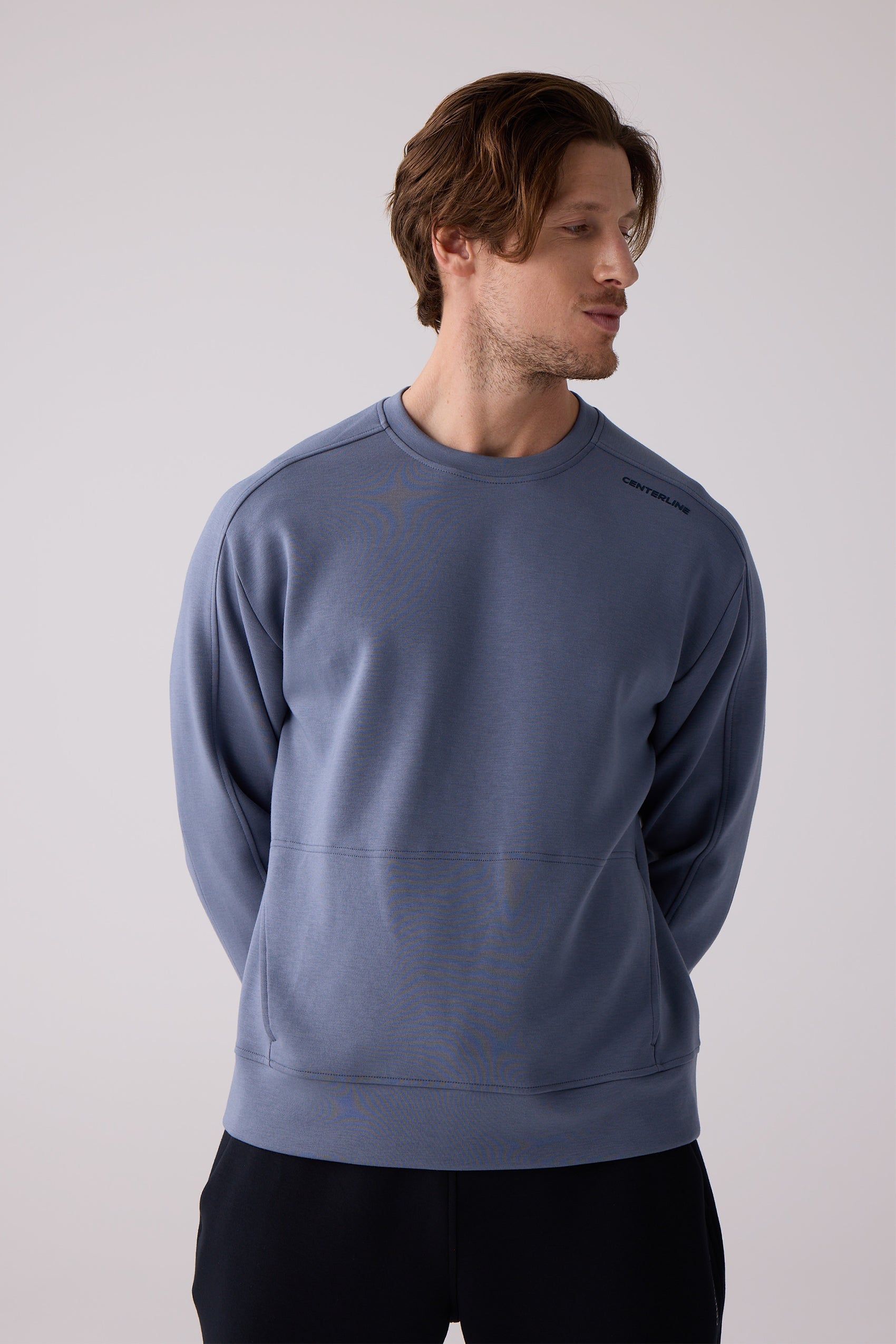 Blue crew neck sweatshirt by Centerline Athletics with visible shoulder seams and branding on the right shoulder, worn by a man.