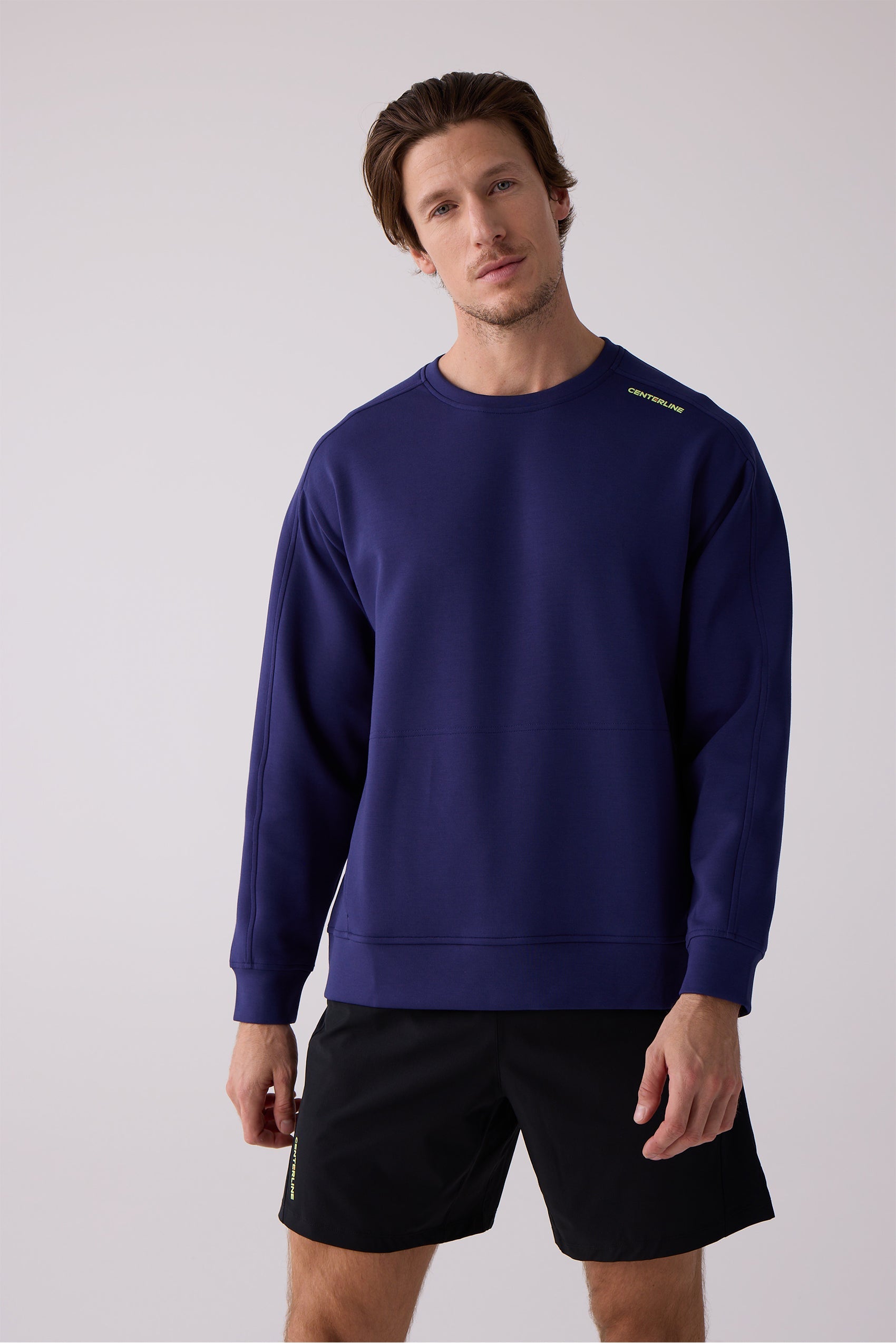 Navy blue Men's Crew Sweatshirt by Centerline Athletics with lime green 'CENTERLINE' text on shoulder, visible seam details, and black shorts.