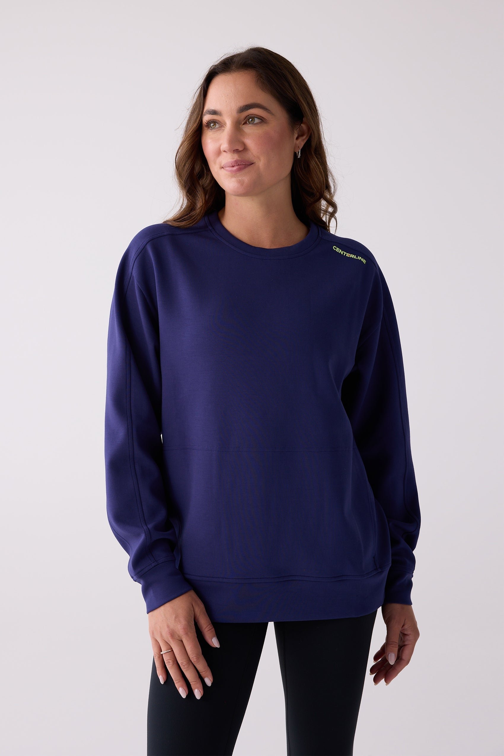 Dark blue crew sweatshirt by Centerline Athletics, with lime green 'CENTERLINE' text on the shoulder and visible stitching, worn by a woman with black leggings.
