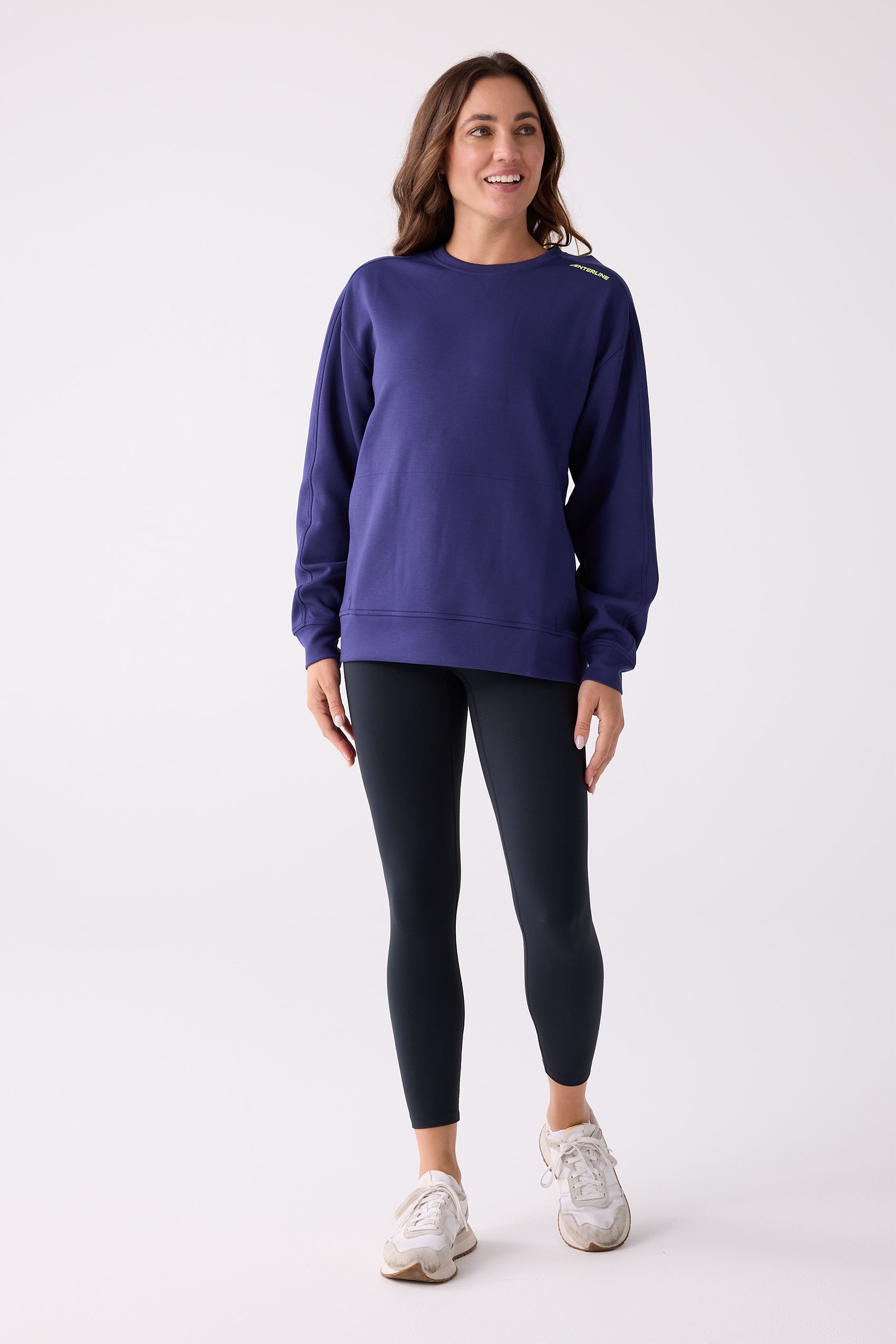 Dark purple crew sweatshirt by Centerline Athletics with a lime green logo on the shoulder, worn with black leggings.