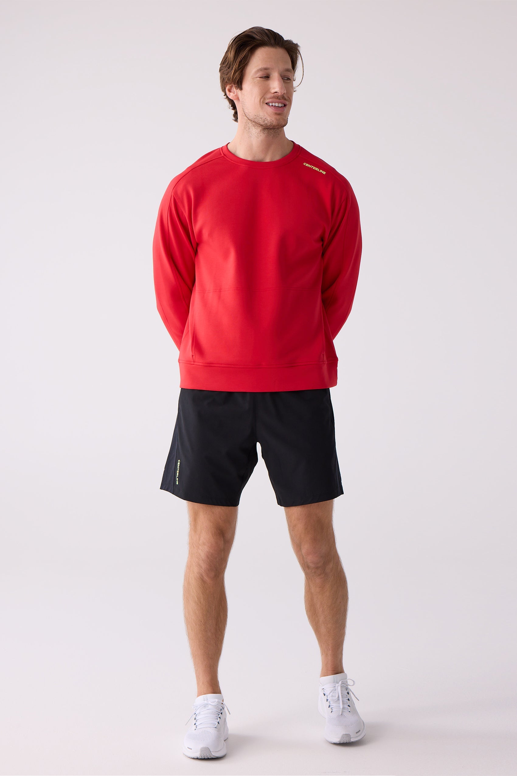 Red men's crew sweatshirt by Centerline Athletics, featuring yellow 'CENTERLINE' text on the left shoulder, worn by a man with black shorts and white sneakers.
