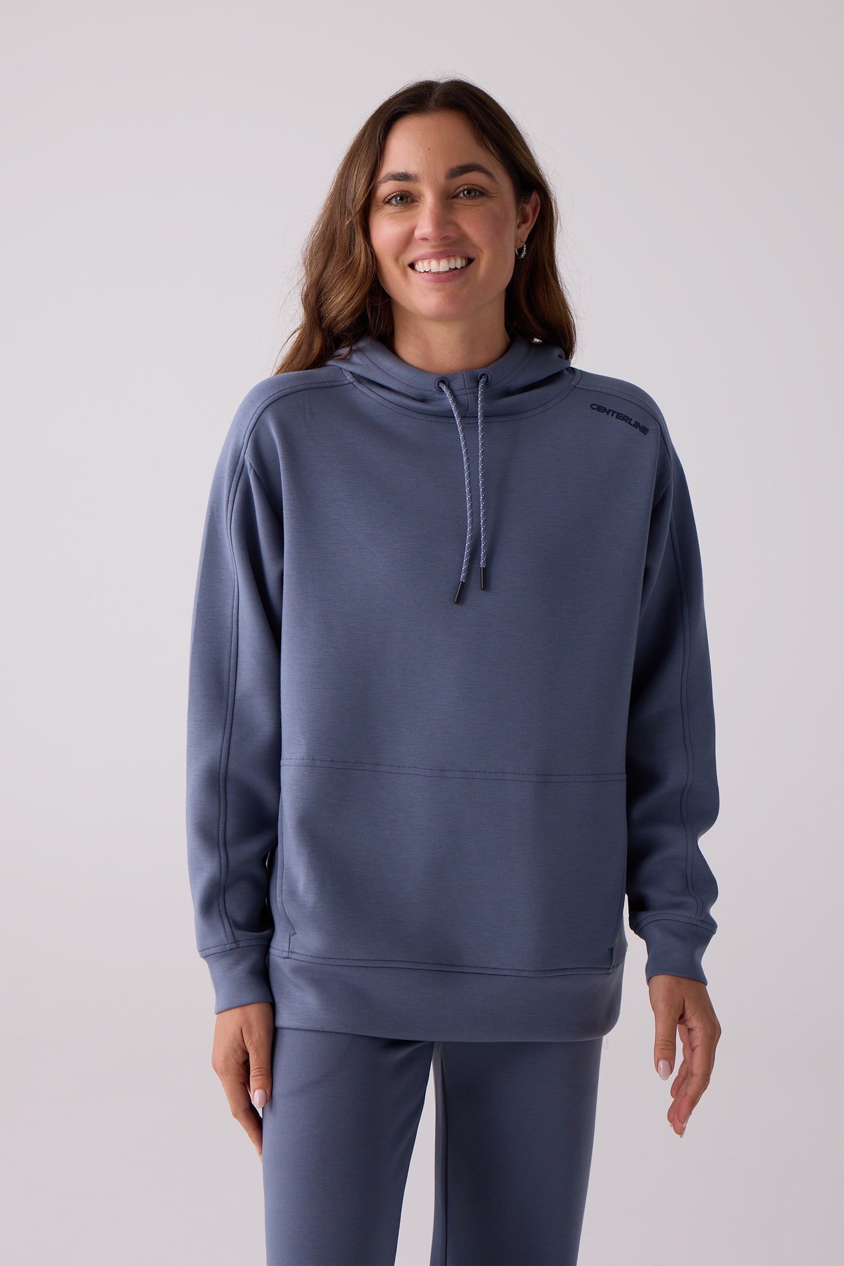 Blue-grey women's hooded sweatshirt by Centerline Athletics, featuring a black logo on the shoulder, drawstrings, and matching pants.
