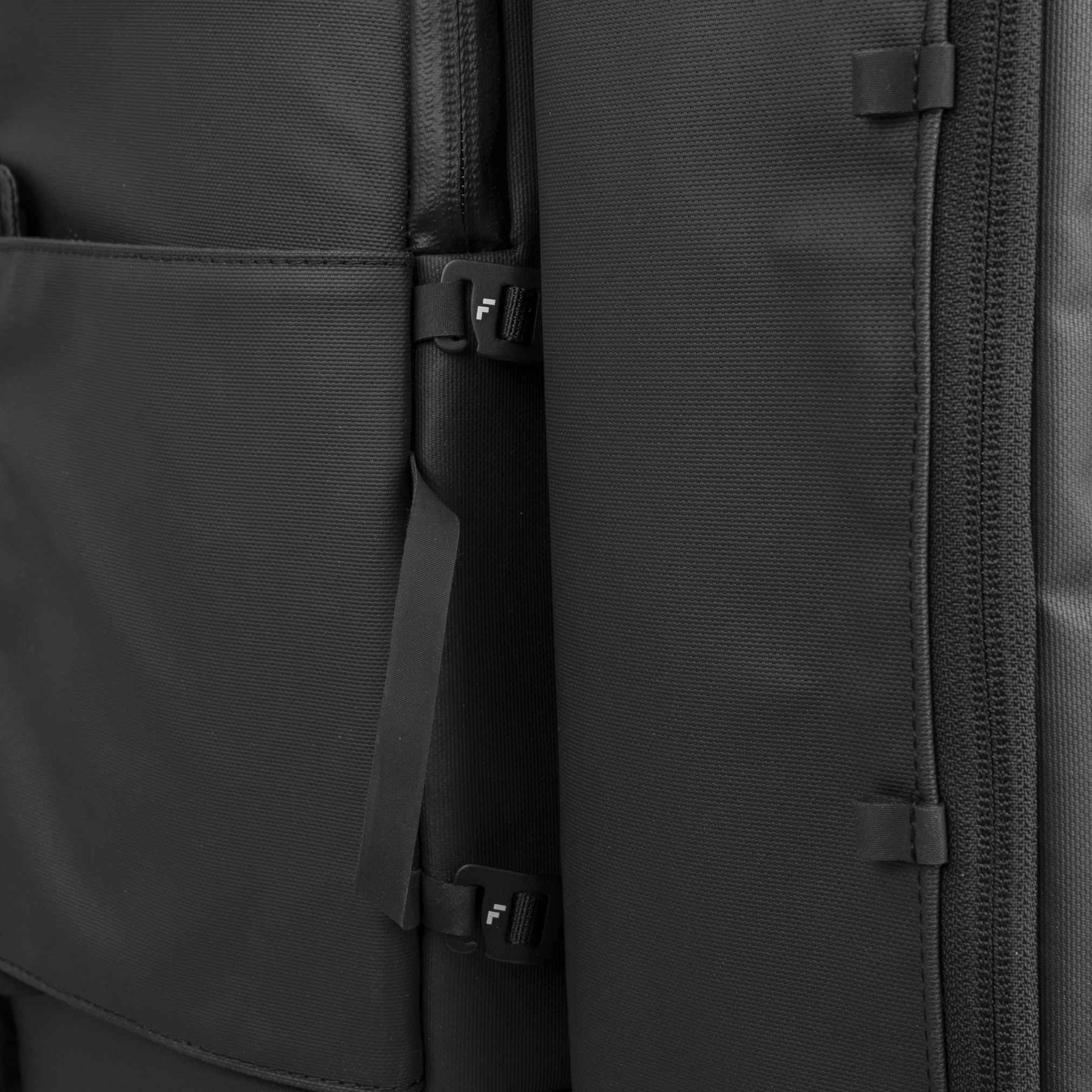 Black shoe cube by FORWRD, a cropped close-up showing textured woven fabric, zippers, and black clips with a white 'F' detail.