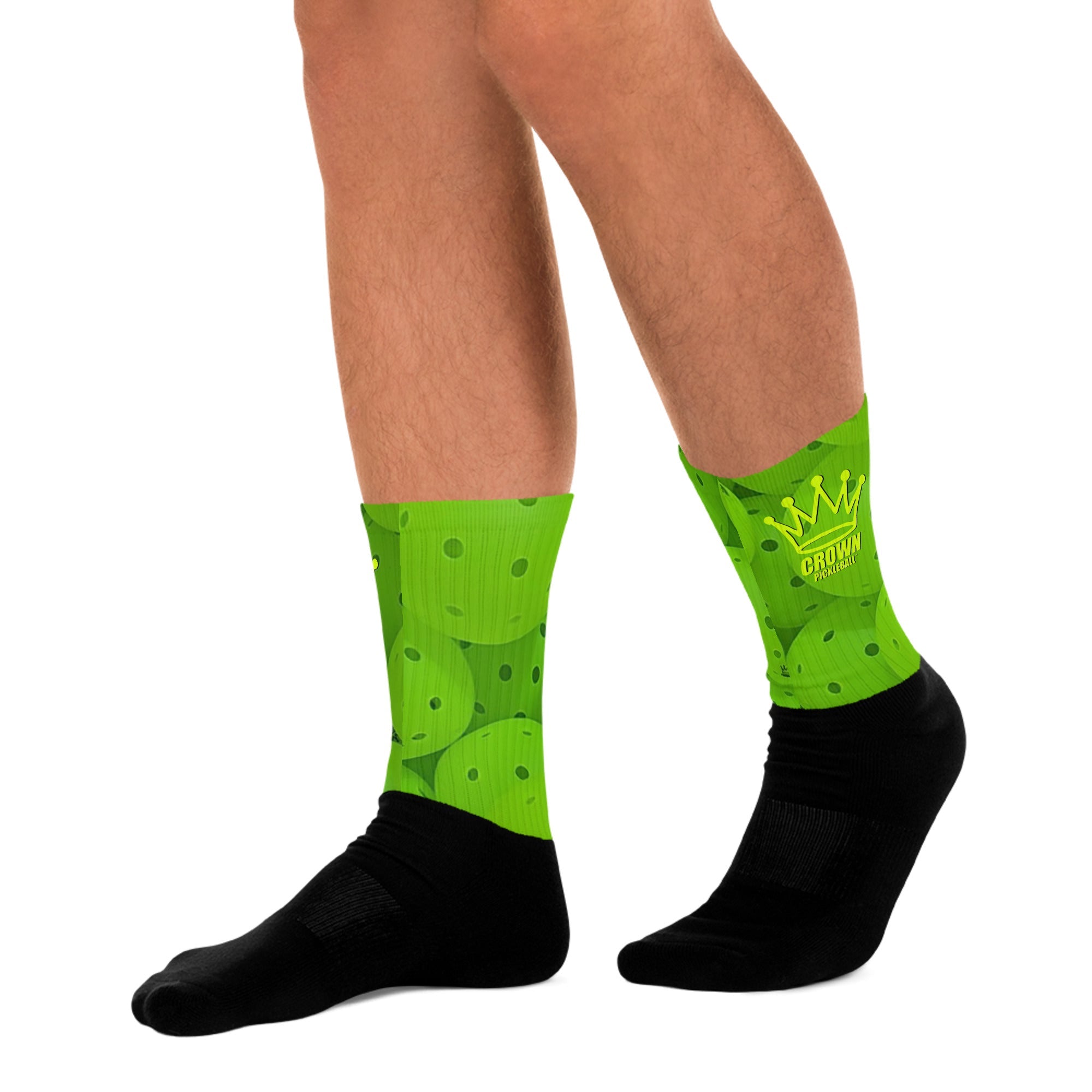 Two legs wearing green and black pickleball socks.