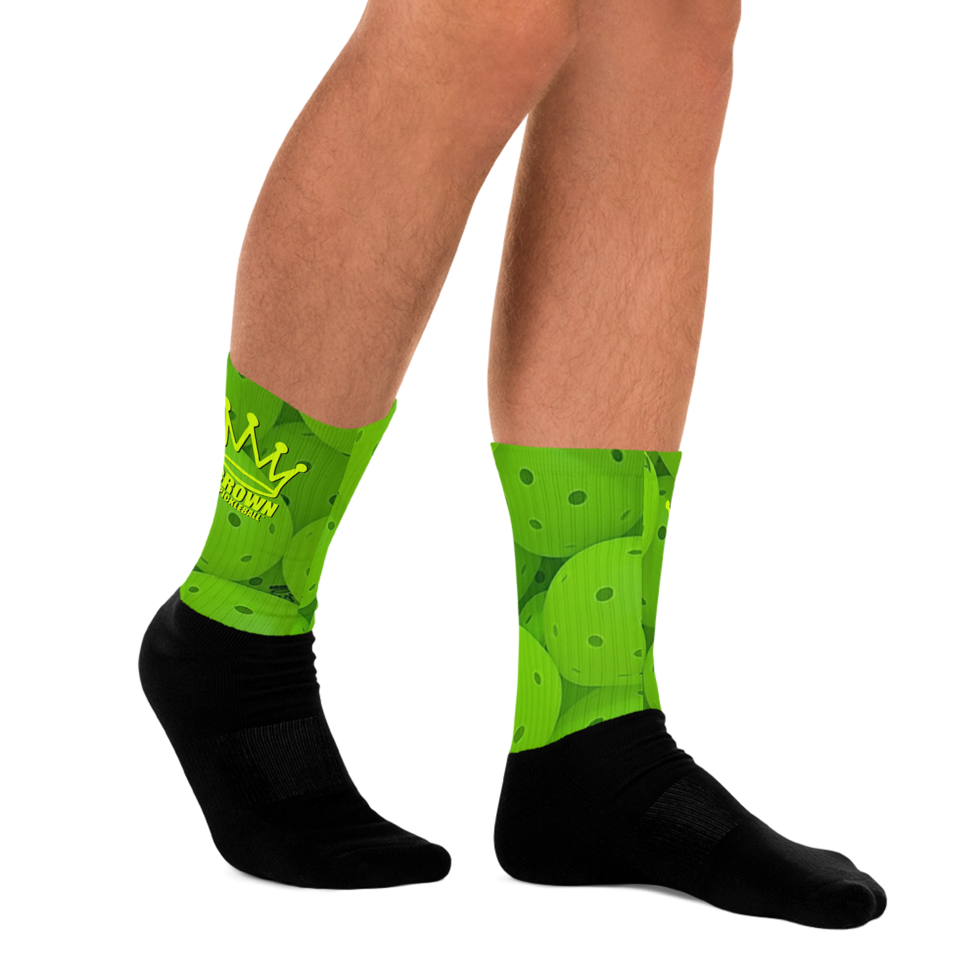 A person is wearing bright green and black socks with a pickleball design.