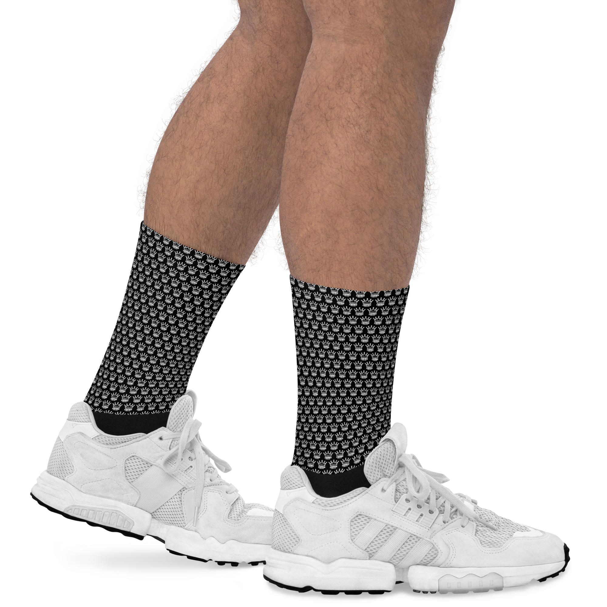 Person wearing white sneakers and socks with a crown pattern.