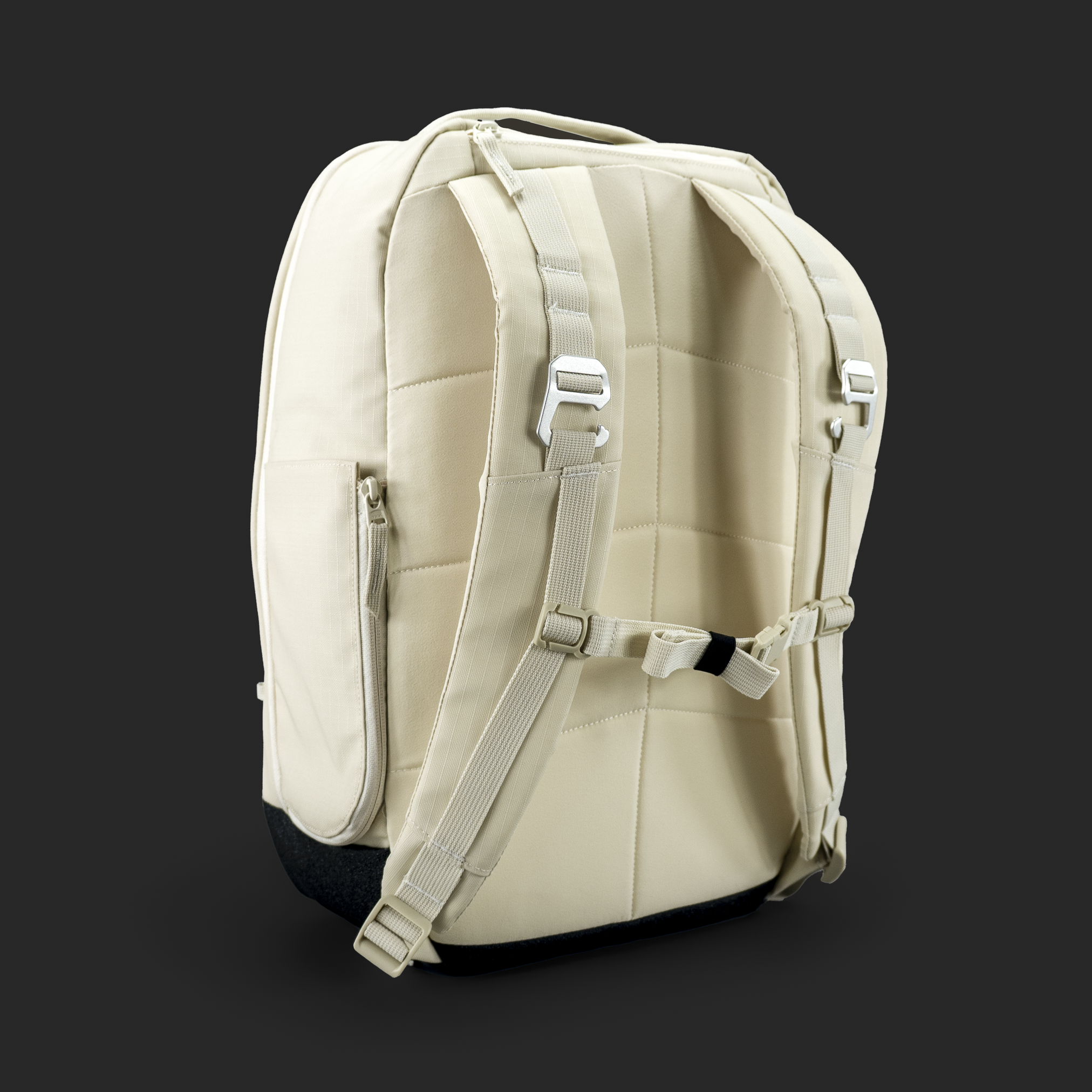 Tan backpack with padded straps, zippers, and buckles on a black background.