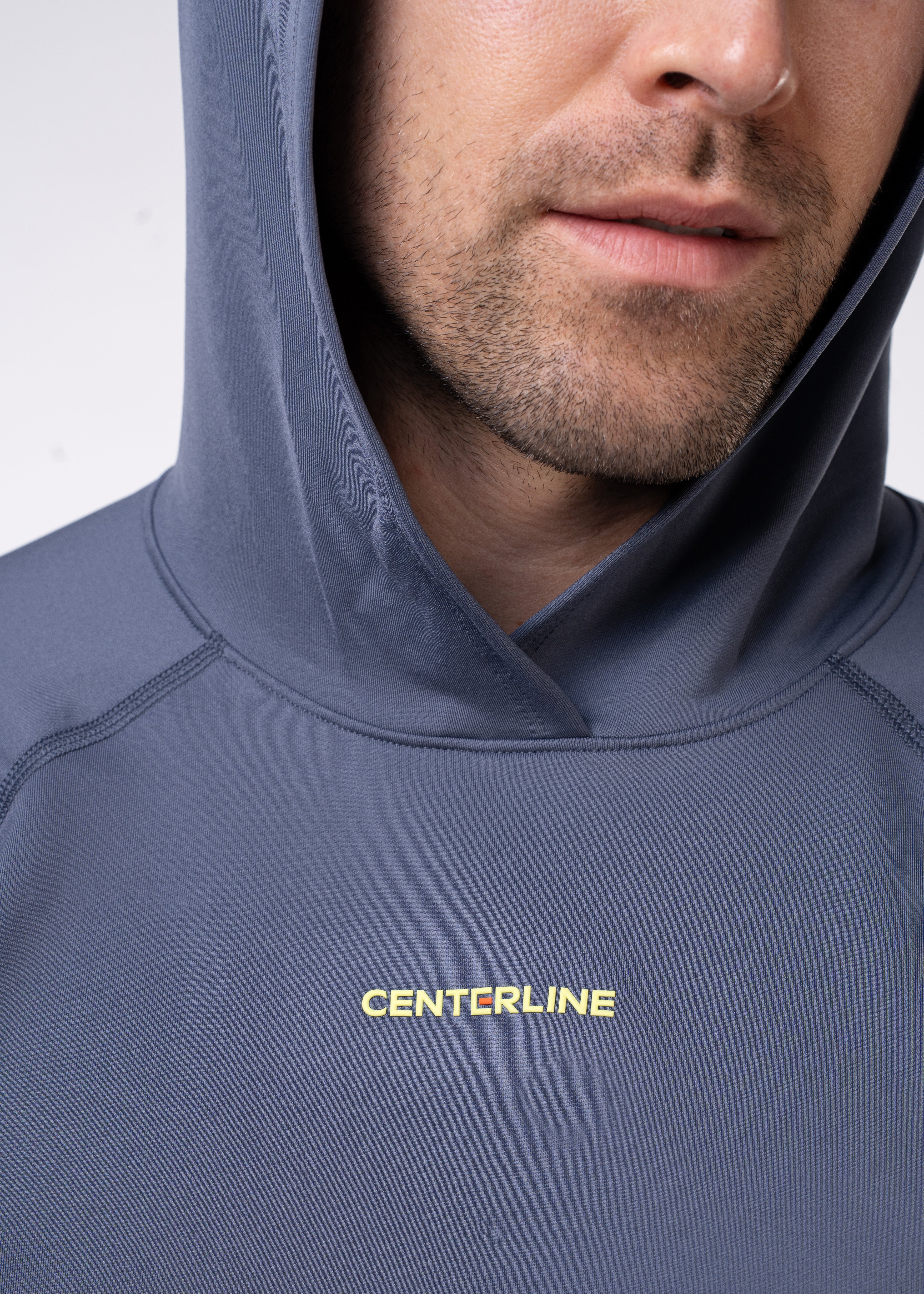Close-up of a man wearing a hooded blue athletic shirt with yellow "CENTERLINE" text.
