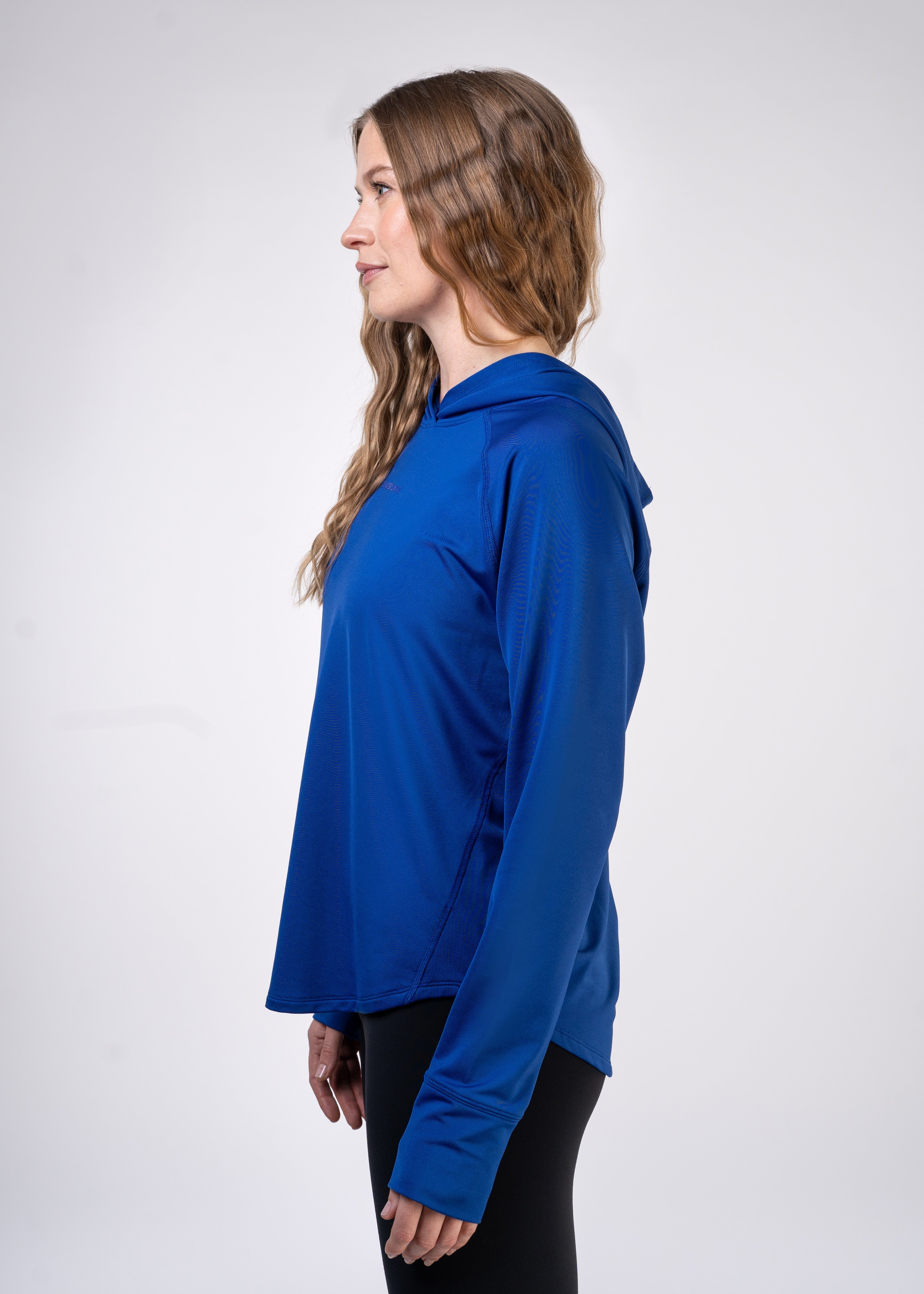 Woman in blue hooded athletic top and black leggings, side profile.
