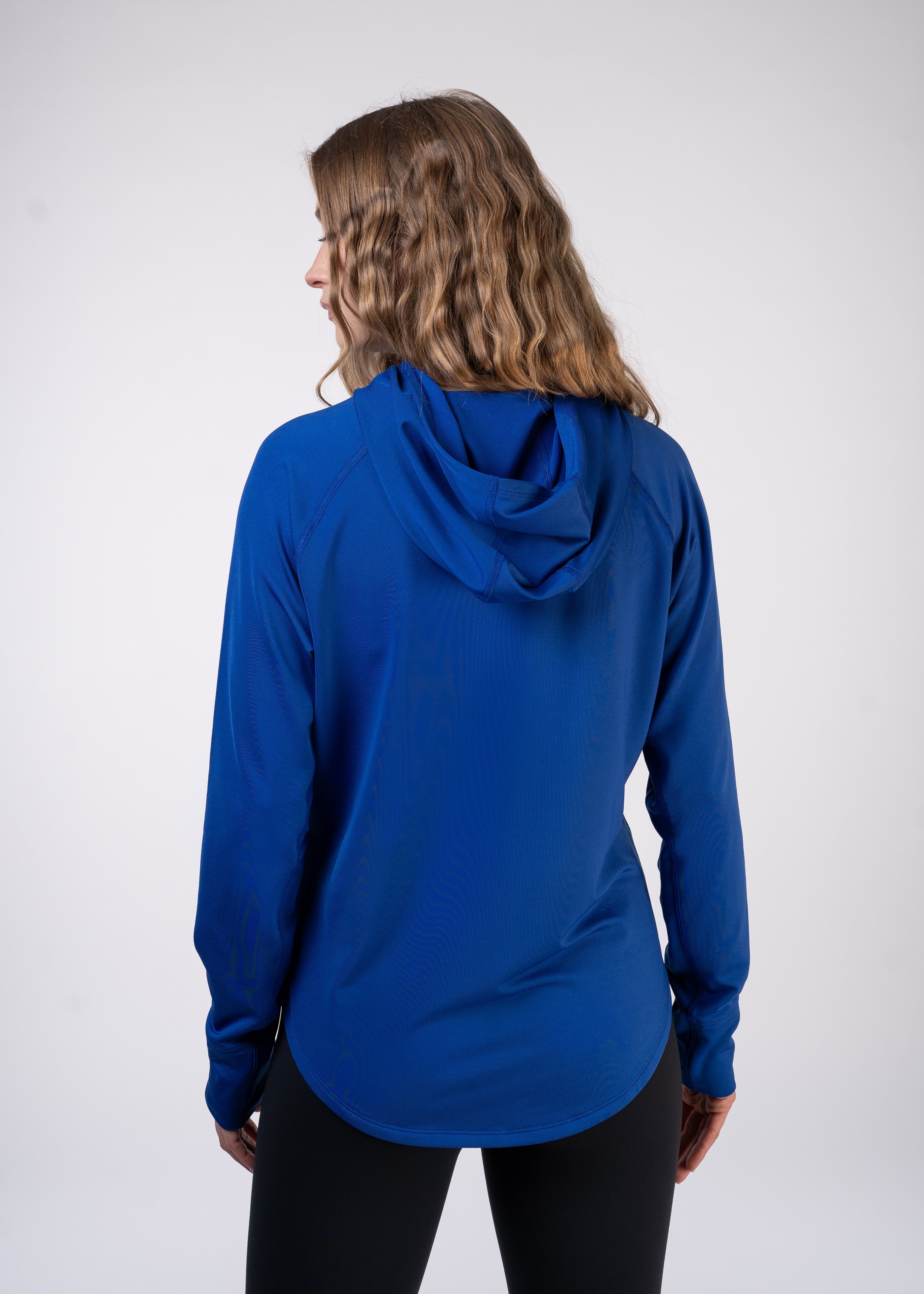 Woman wearing blue hoodie and black leggings, rear view.