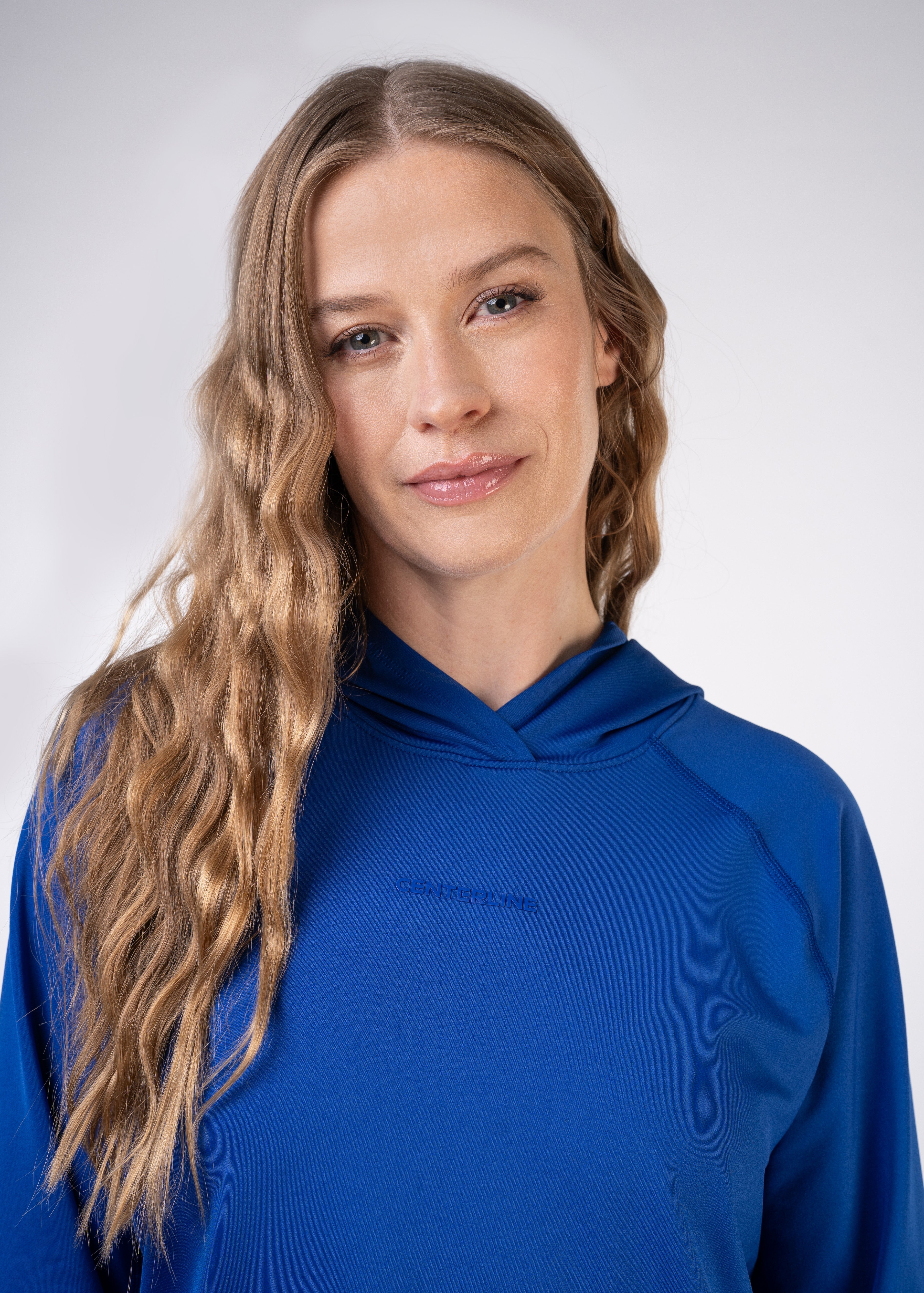 Woman in blue hoodie with "CENTERLINE" text.