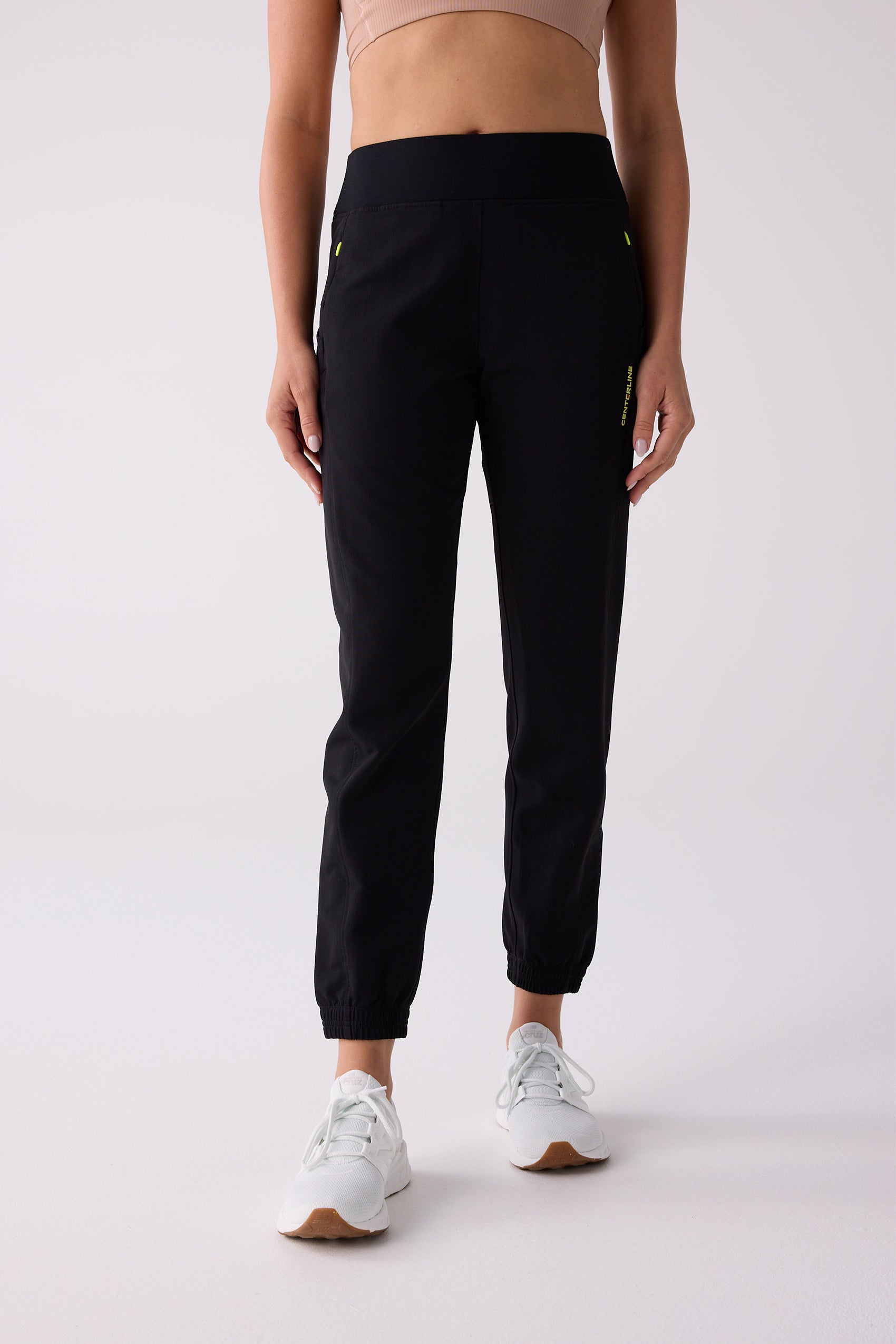 Black Women's Courtside Track Pants by Centerline Athletics, with a high-rise waist, neon yellow accents, and elastic cuffs.