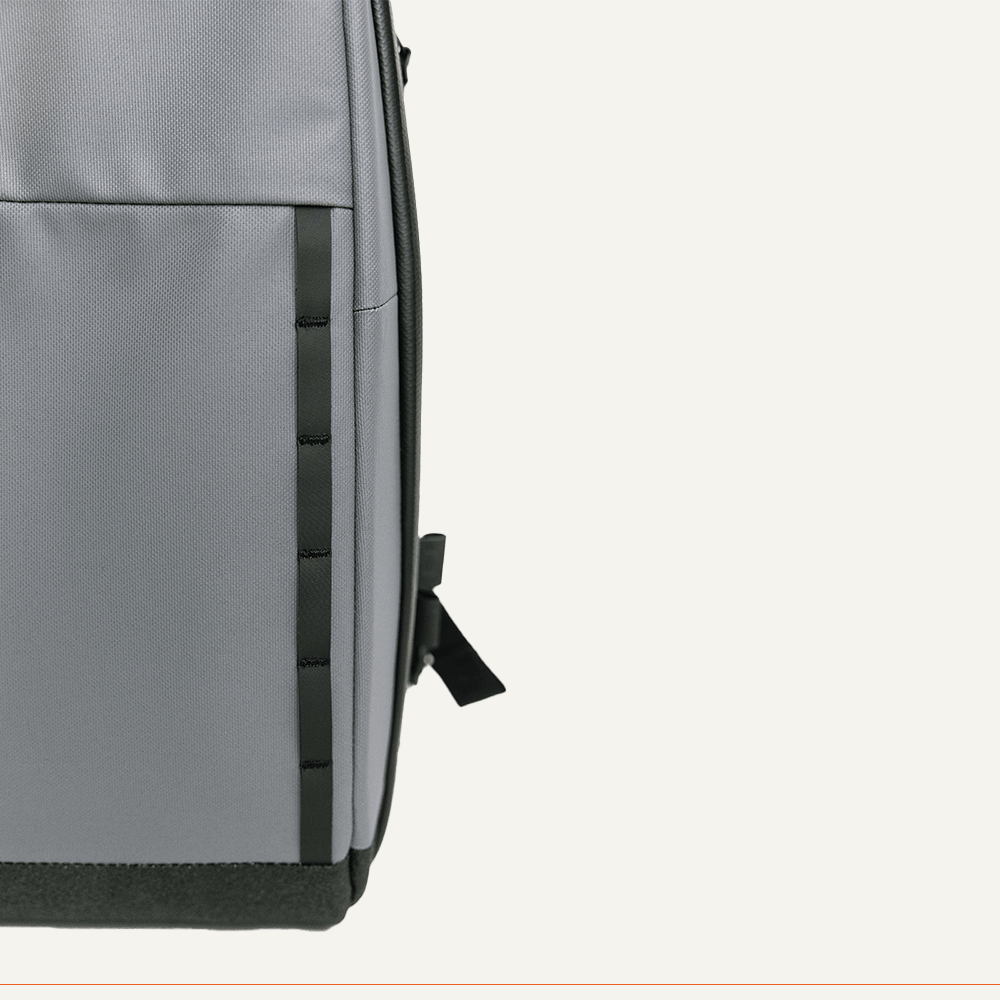 Gray pickleball sling by FORWRD with black trim, a vertical webbing strip, and a black pull tab, shown from the side.
