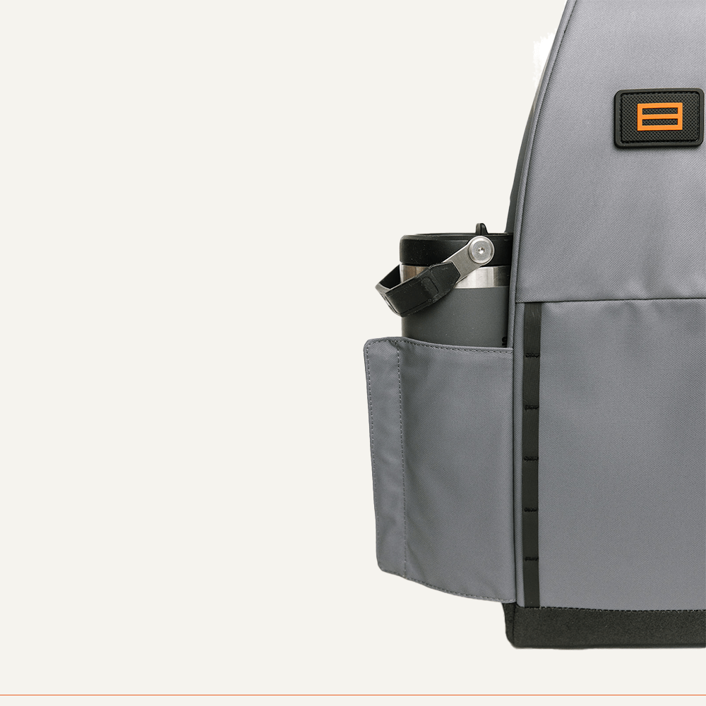 Gray backpack with water bottle in side pocket.