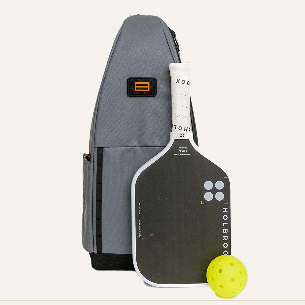 Gray pickleball bag, paddle, and yellow ball.