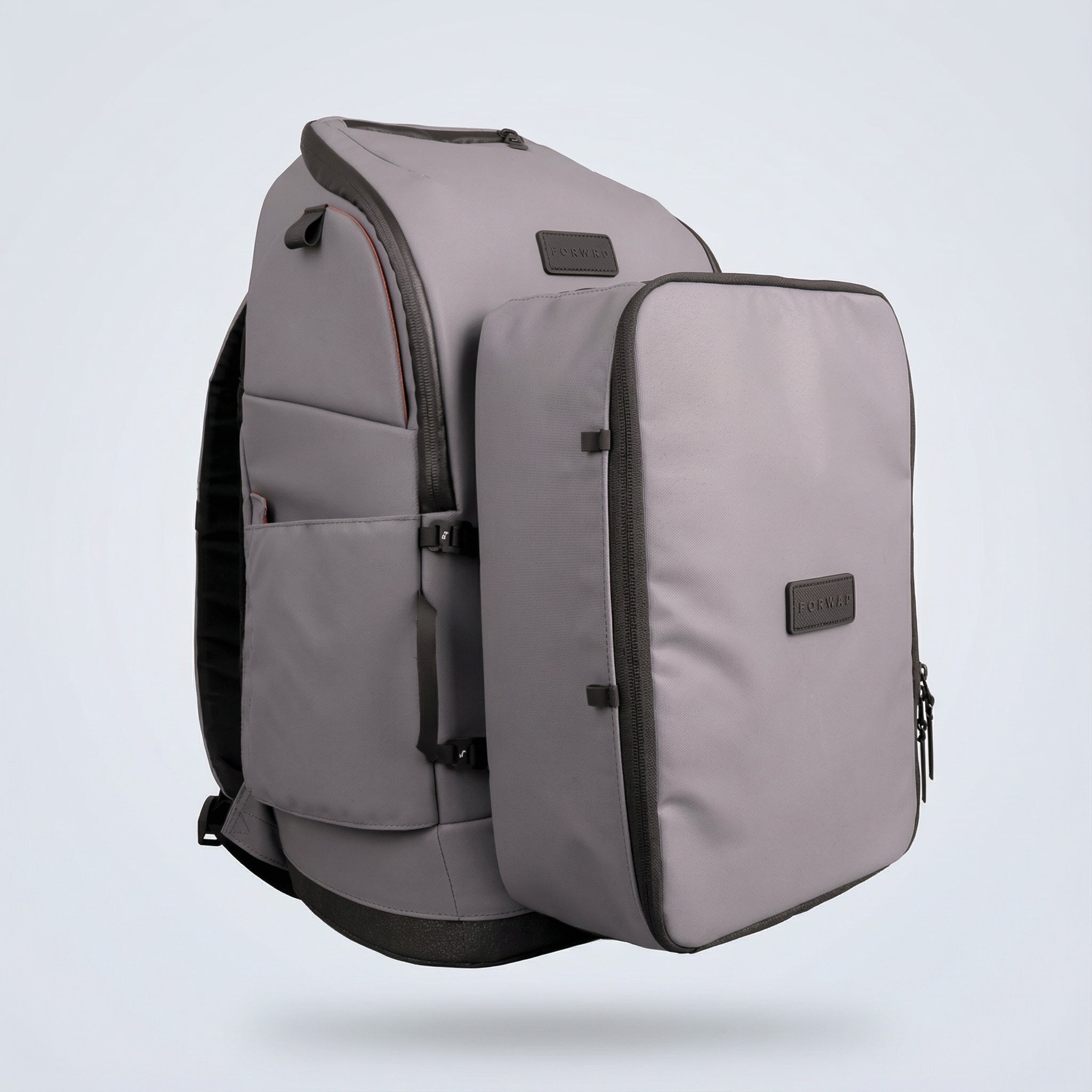 Grey shoe cube by FORWRD, with black zippers and a discreet logo, attached to a larger grey backpack.