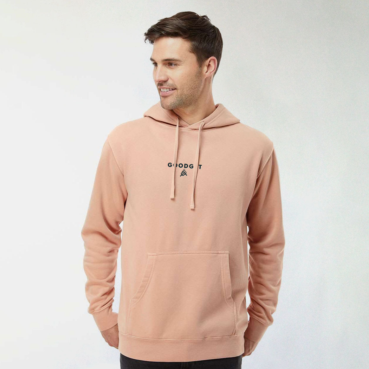 Peach Men's Everyday Hoodie by Good Get with black embroidered logo, drawstrings, and kangaroo pocket, worn by a man.