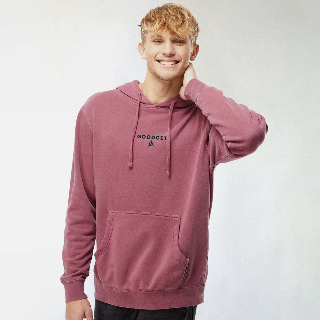Maroon hoodie by Good Get, with 'GOODGET' text and a small logo on the chest, worn by a smiling man.
