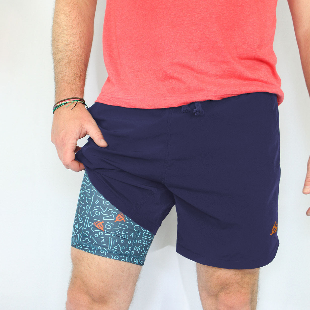 Person wearing a salmon-colored t-shirt and dark blue running shorts with a colorful, patterned inner layer.