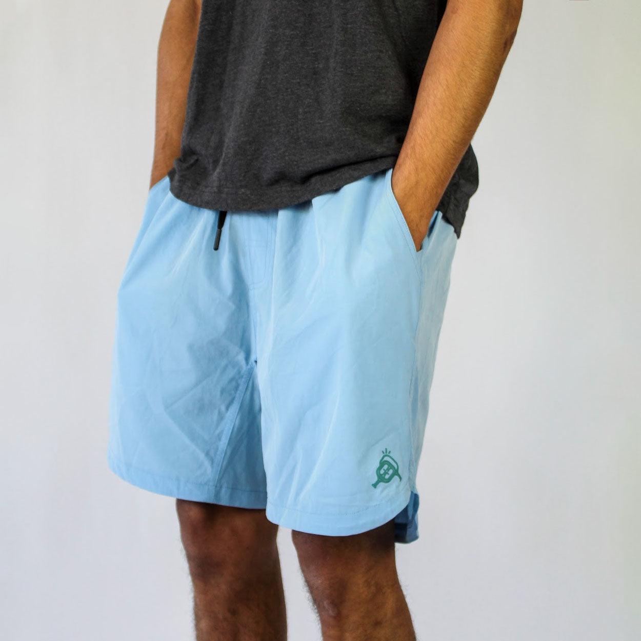 Person wearing gray t-shirt and light blue shorts with logo.