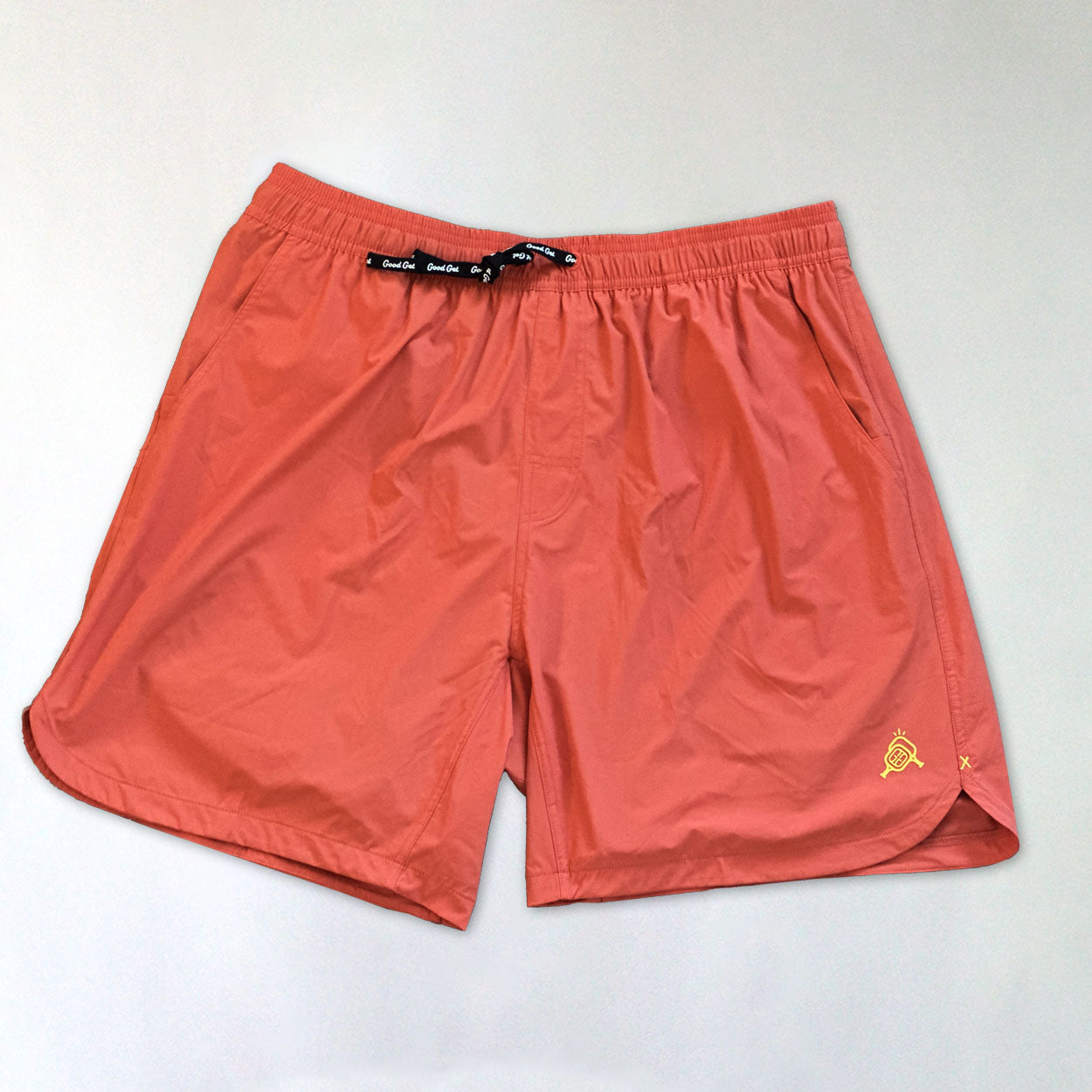 Salmon-colored shorts with black drawstring.