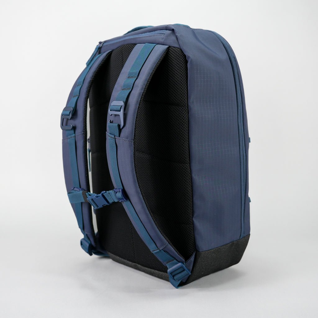 A blue backpack with a black mesh back panel and blue straps.