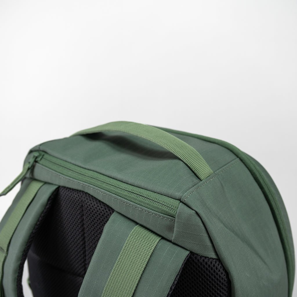 Green fabric Pickleball Backpack by FORWRD, close-up back view with top handle, zippered compartment, and padded mesh straps.