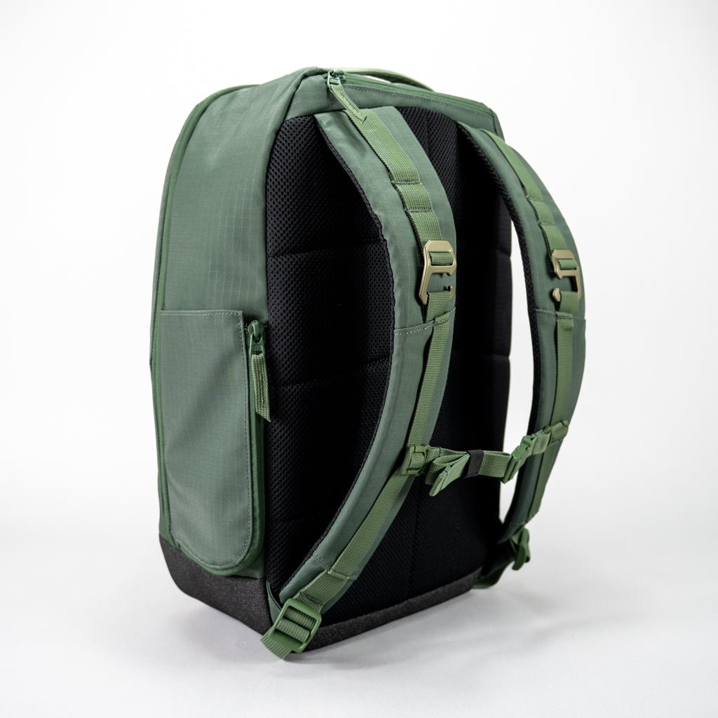 A green pickleball backpack by FORWRD, featuring a mesh back panel, padded shoulder straps with metal buckles, and a dark gray base. Back view.