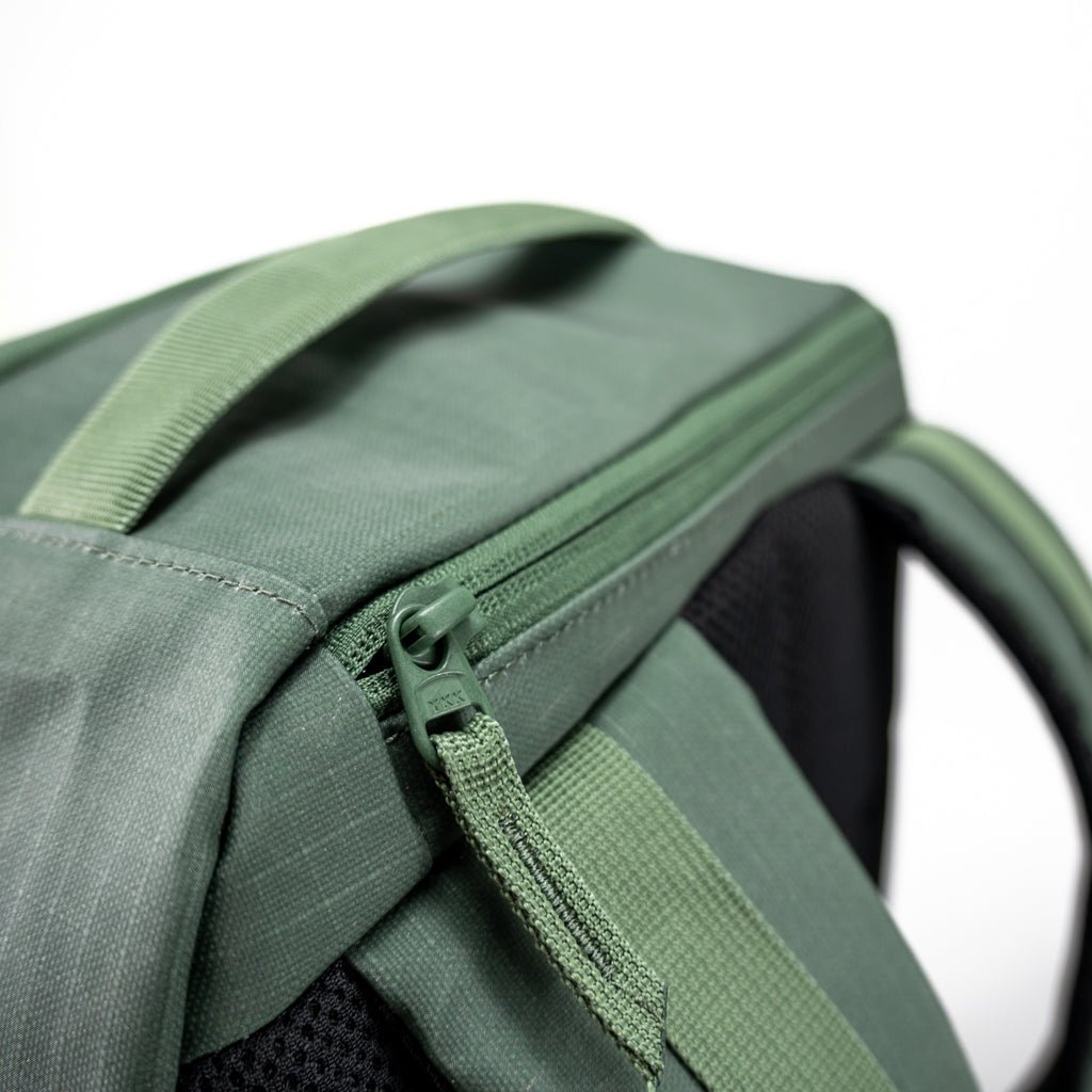 Close-up of a green backpack with a YKK zipper.