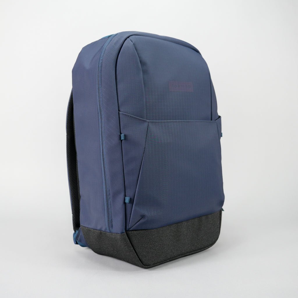 Navy blue pickleball backpack with a black base by FORWRD, featuring a subtle grid pattern, embossed logo, front pocket, and side zipper.