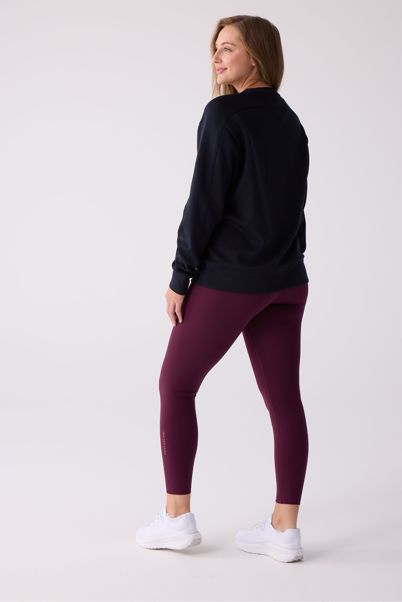 Burgundy 7/8 leggings by Centerline Athletics, with "CENTERLINE" script on the left leg, worn with a navy top and white sneakers.