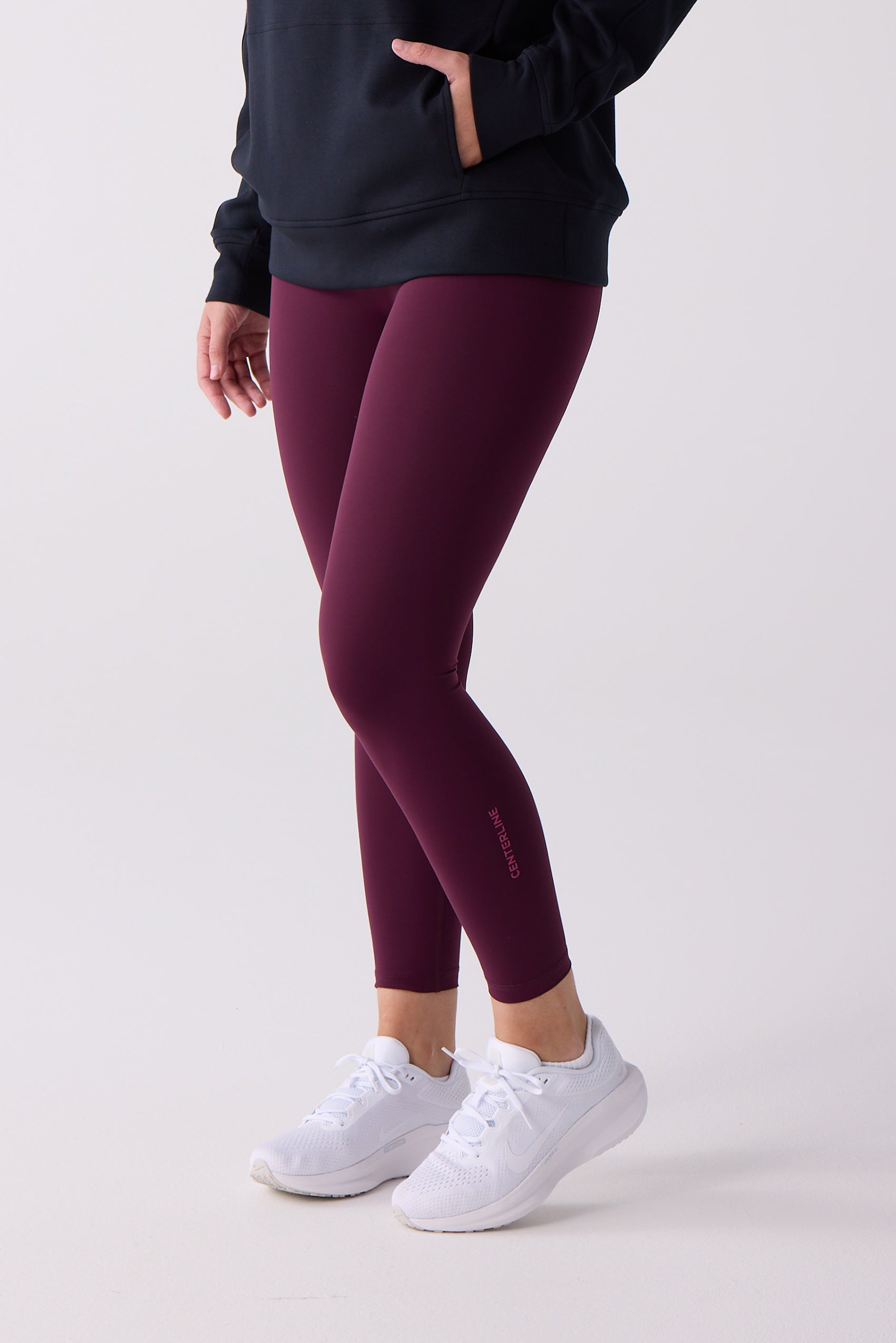 7/8 length maroon legging by Centerline Athletics, featuring "CENTERLINE" logo on the calf, worn with a black hoodie and white sneakers.