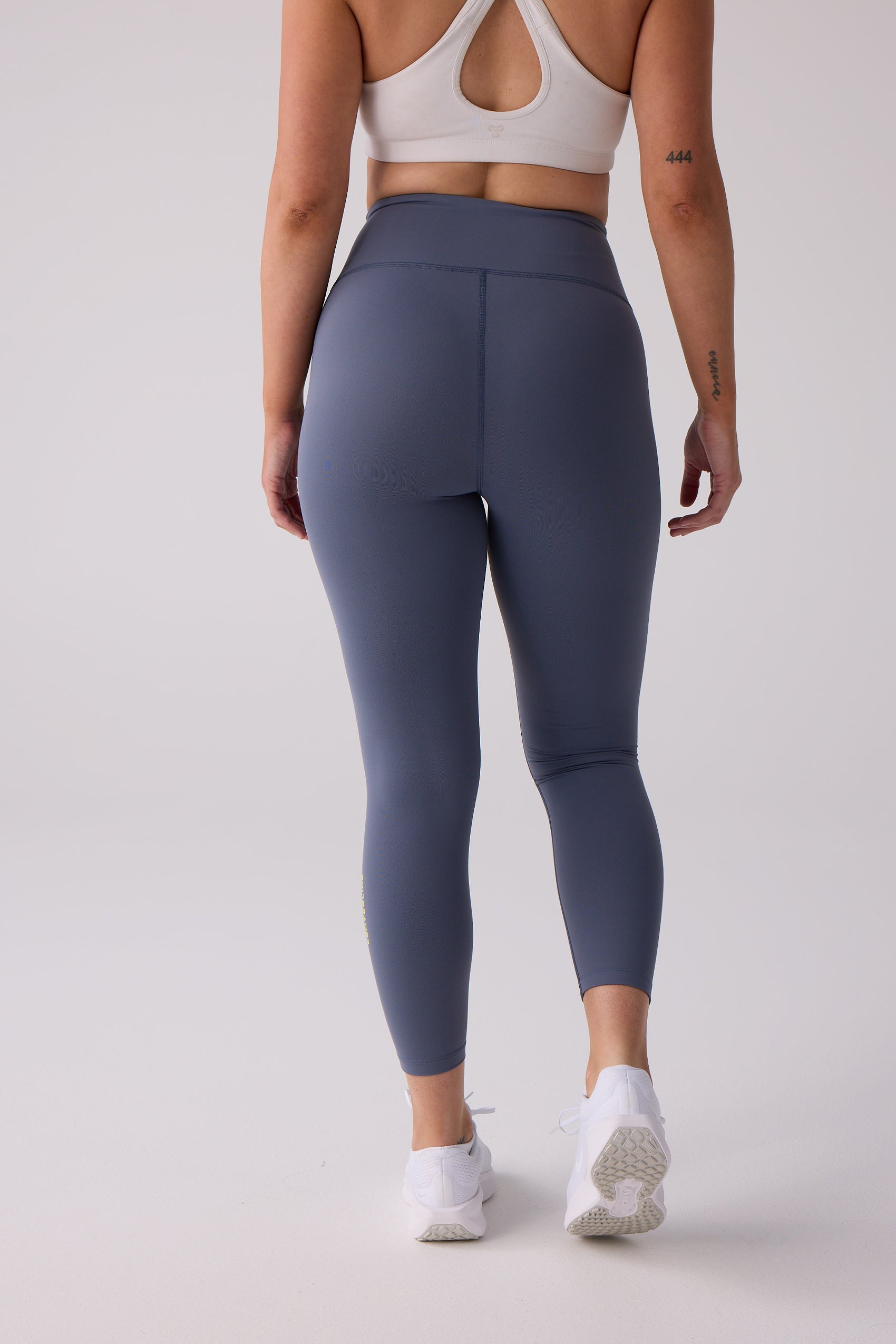 Blue-grey 7/8 leggings by Centerline Athletics, featuring a high-waisted back view with white sports bra and shoes.